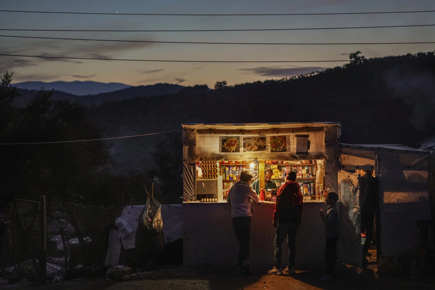  Moria Camp, Lesbos - 23/11/2019  A small shop in the hills of the Moria camp. As asylum procedures slowed, the migrants in the camp became stuck for many months and years. The camp began functioning as a small village. Shops and bakeries popped up a