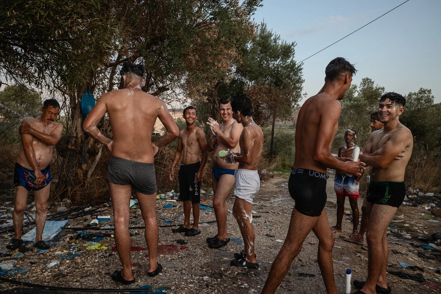  Moria Camp Area, Lesbos - 18/09/2020  Asylum seekers use the water from a broken irrigation hose to wash. 