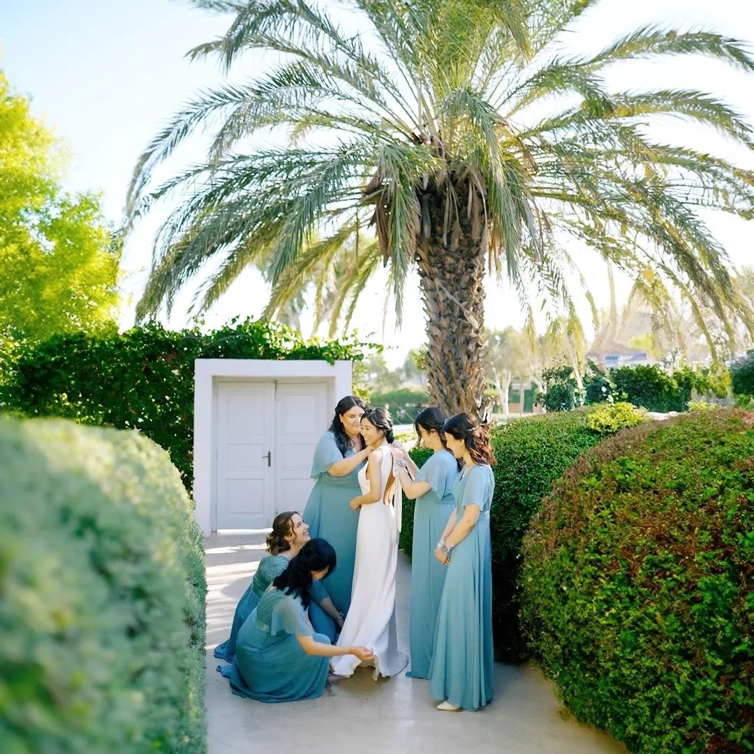 Girl power takes center stage at this dreamy island wedding.

The bridesmaids, dressed in beautiful sapphire blue dresses, surround the bride with love, laughter, and endless support. In this candid moment captured at Island Art and Taste, the girls 