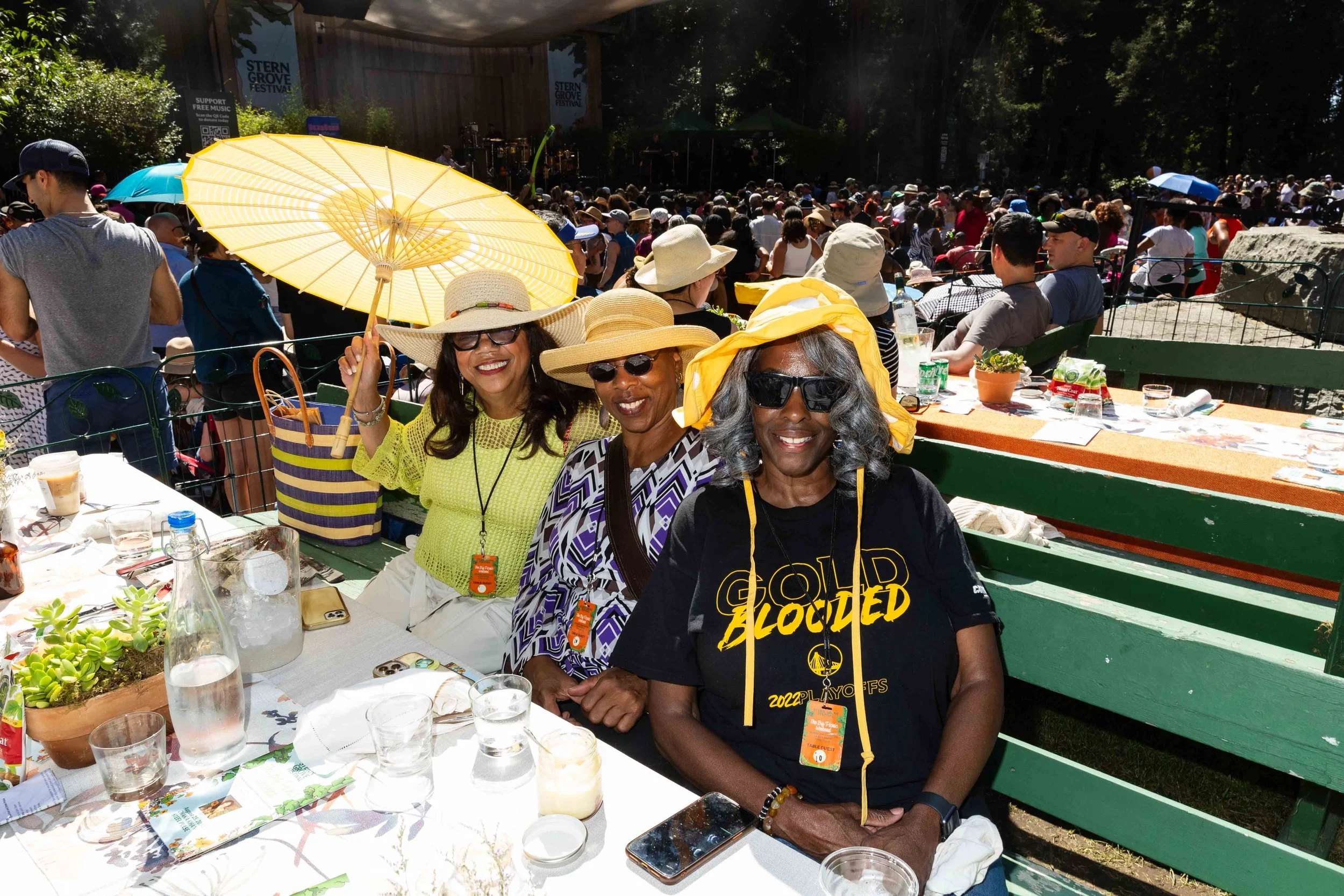 three women seated at a picnic table smiling
