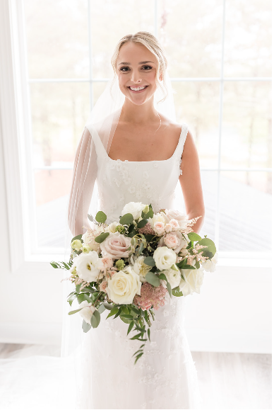 Clean aesthetic bridal updos with face-framing tendrils and cohesive bridesmaid makeup for a high-end North Carolina wedding.