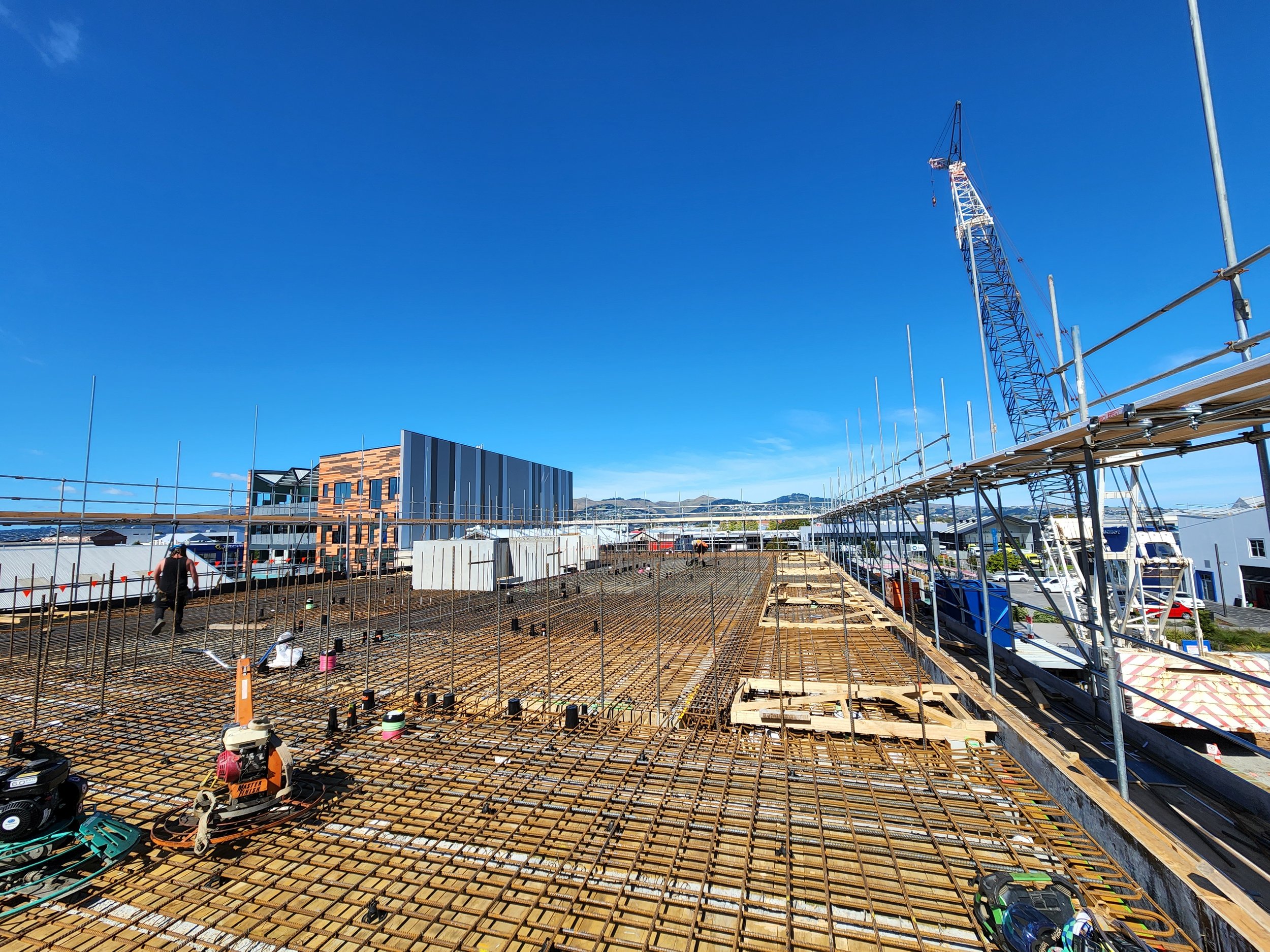 commercial site with crane in the background showing steel tied in the foreground.