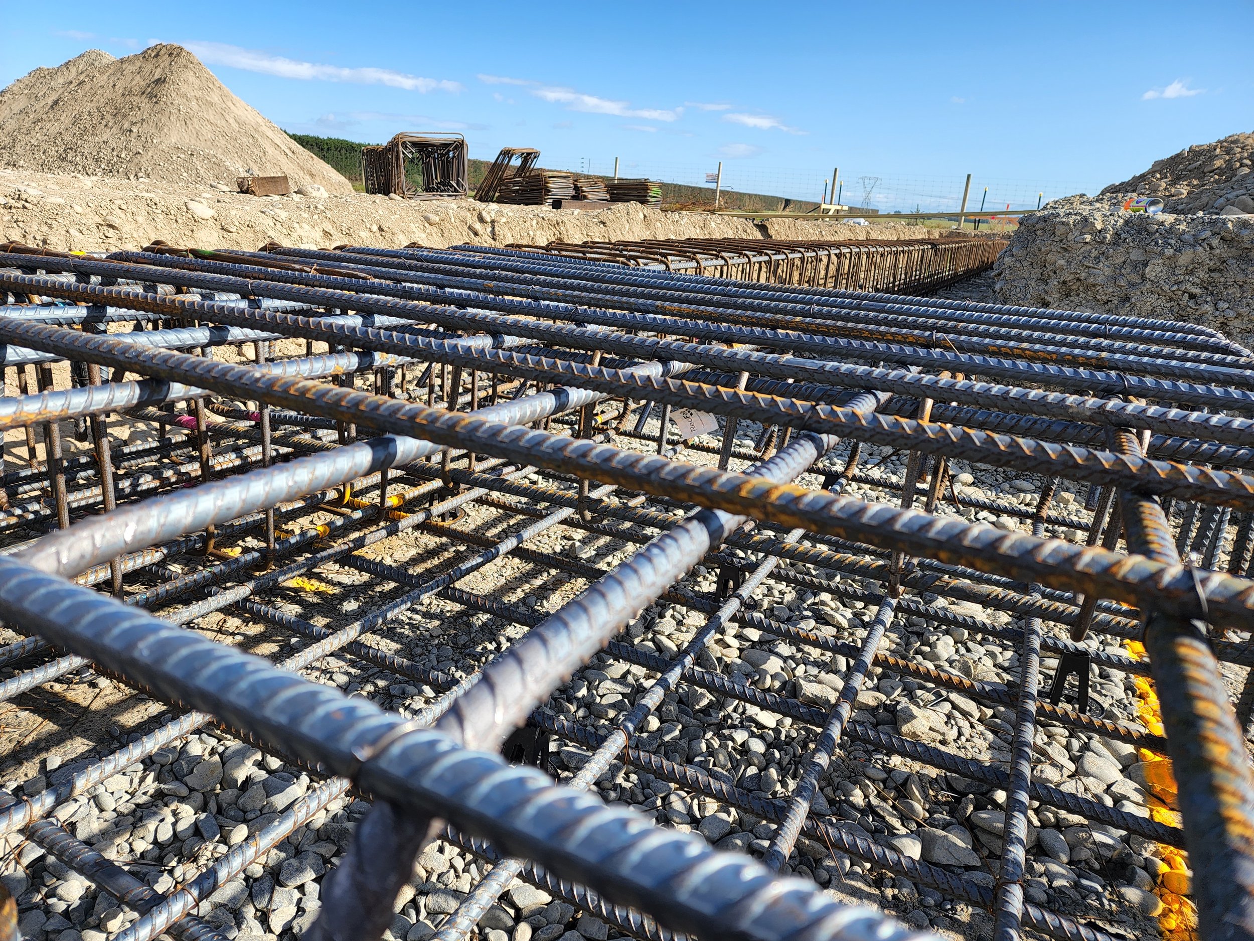 close up of tied rebar steel in the ground on the worksite with blue skies