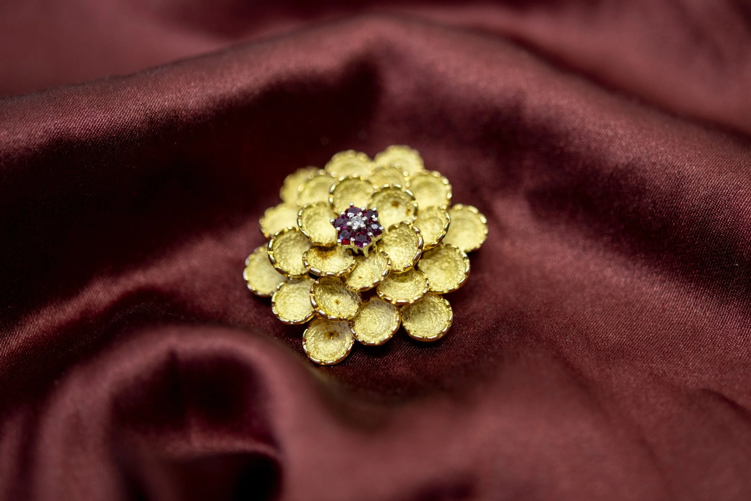 AN 18 CARAT GOLD RUBY AND DIAMOND FLOWER HEAD BROOCH