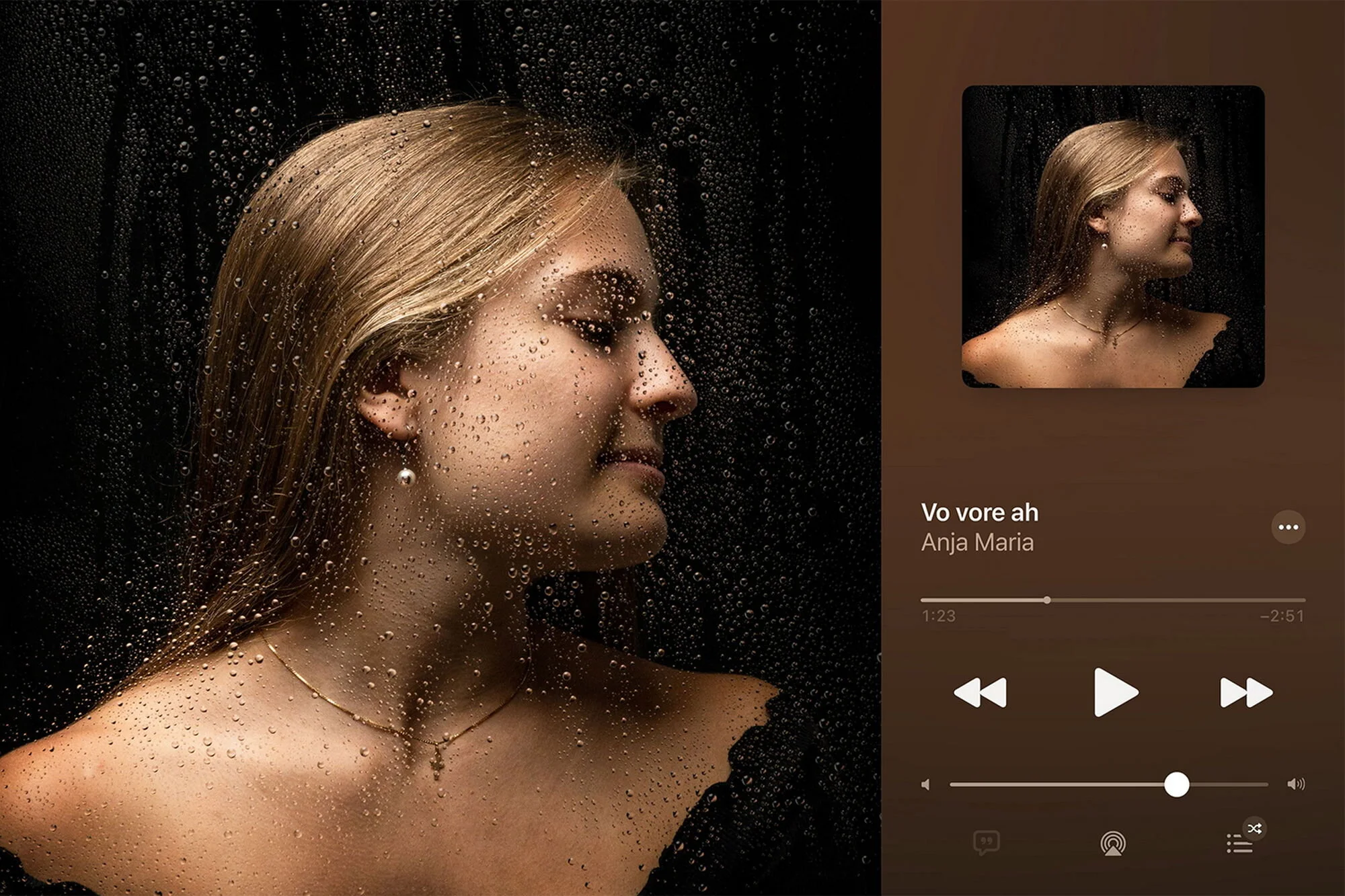 Ein Porträt einer jungen Frau mit nasser Haut und nassen Haaren, aufgenommen hinter einer Fensterglasscheibe mit Wassertröpfchen, auf einem Smartphone-Bildschirm. Sie trägt eine Halskette und Ohrringe, neben einem Musik-Player mit dem Titel 'Vo vore ah' von Anja Maria, Wiedergabesteuerungen und Lautstärkeregler.