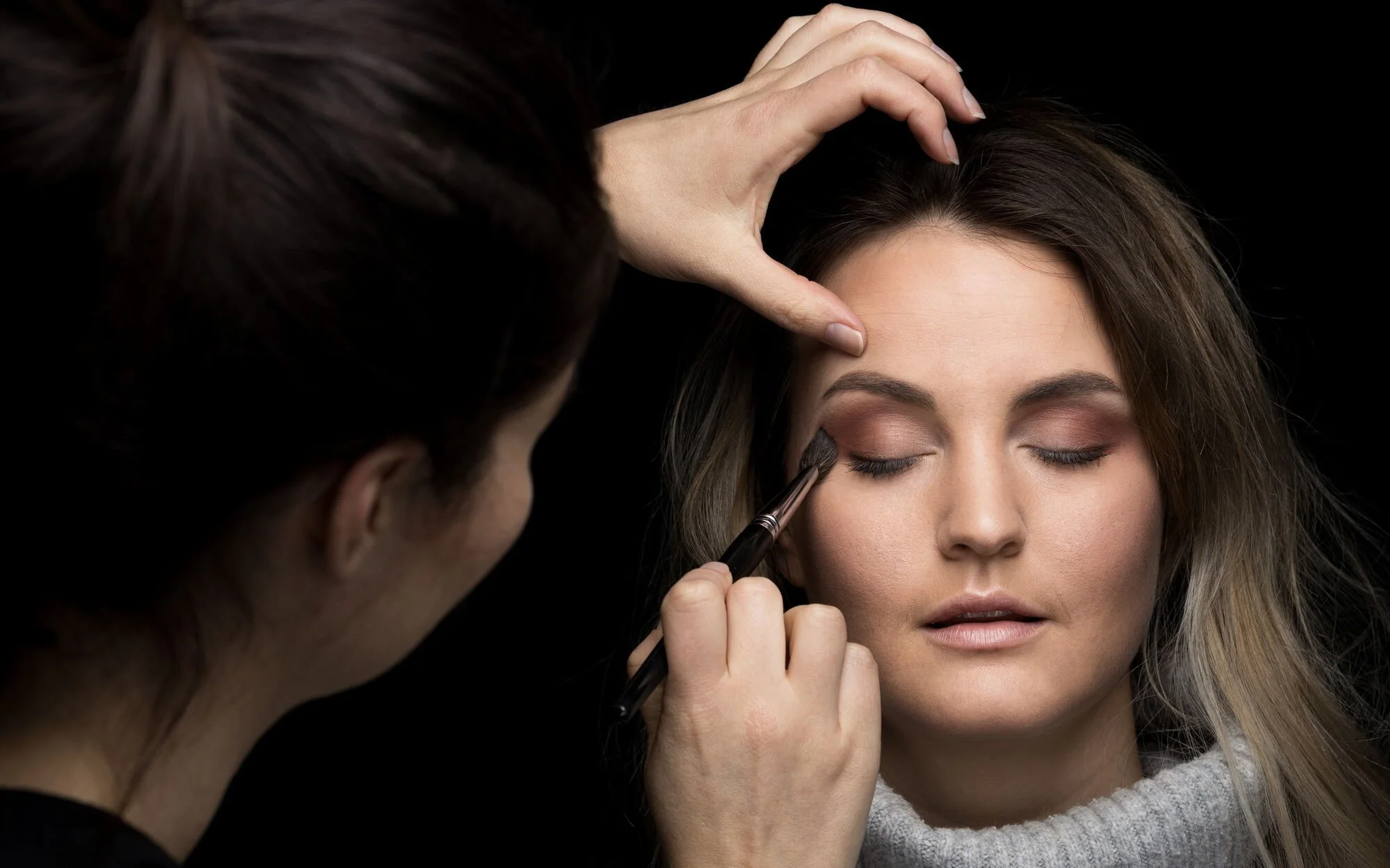 Friseur macht Make-up an Frau