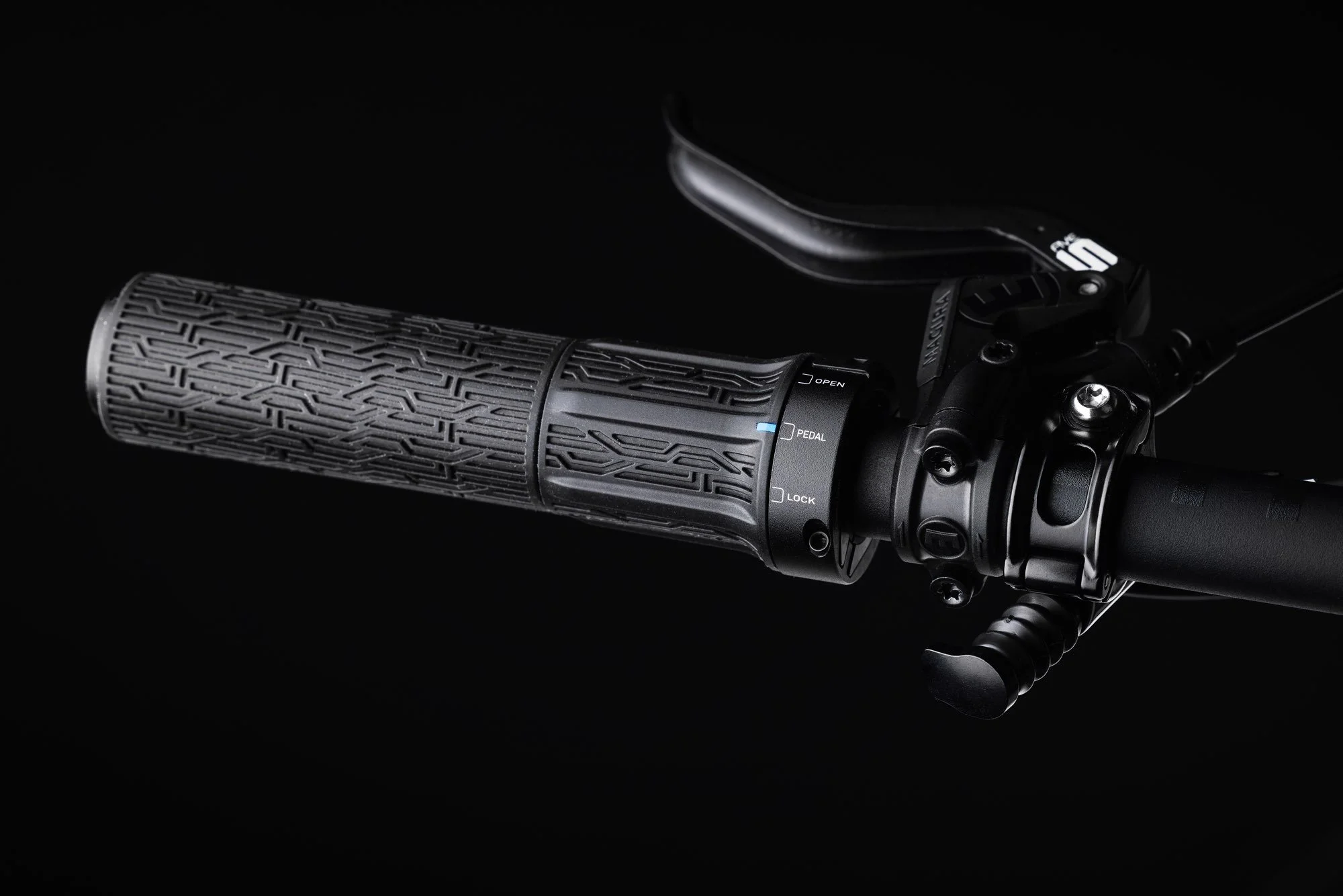 Schwarzer Fahrradlenker mit griffigem Handlauf und Schalthebel, auf schwarzem Hintergrund.