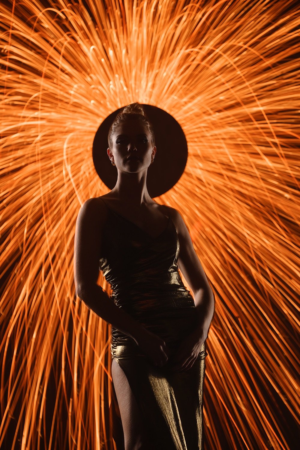 Silhouette einer Frau vor einem leuchtenden Feuerwerk im Hintergrund.