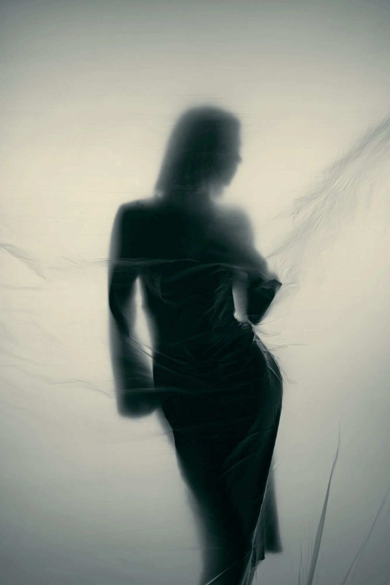 Silhouette einer Frau, die hinter einer schmutzigen Glasscheibe steht.