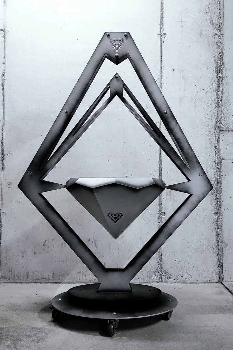 Ein fahrbarer, modern gestalteter Metallsarg, der die Ethereum-Kryptowährung symbolisiert, vor einer Betonkulisse.