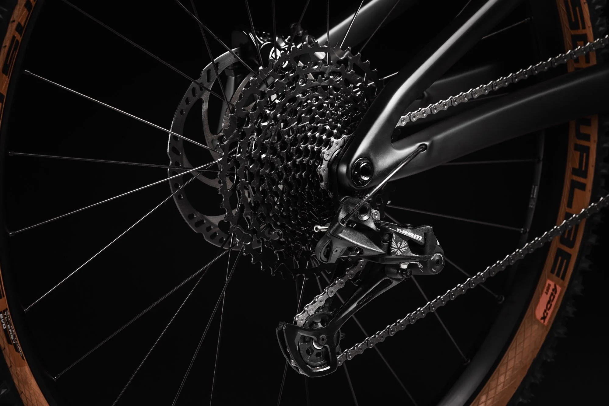 Nahaufnahme des Hinterrads eines Mountainbikes, zeigt Getriebe, Kassette, Kette, Schaltwerk und Reifen.