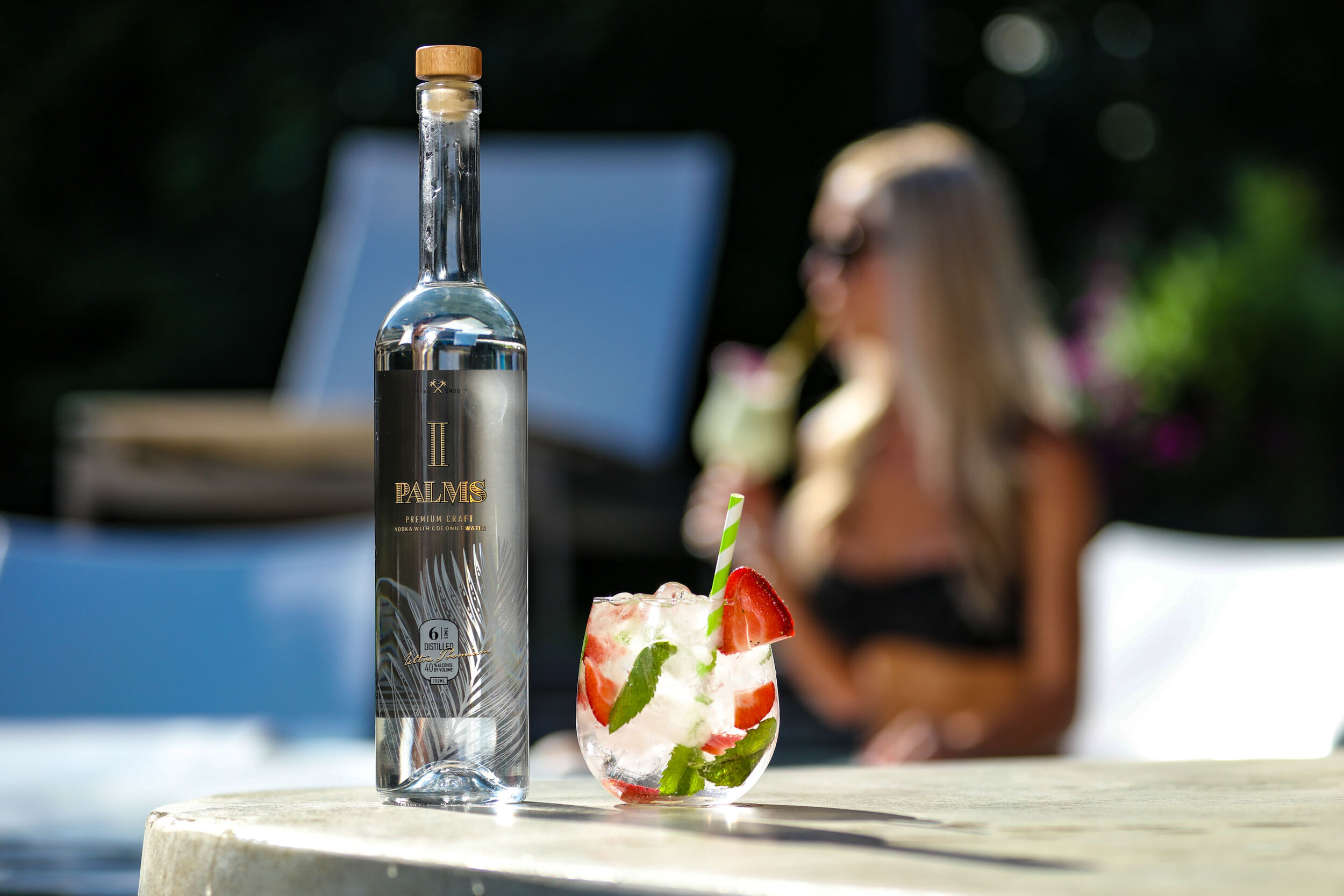 Vodka bottle and cocktail on a poolside bar