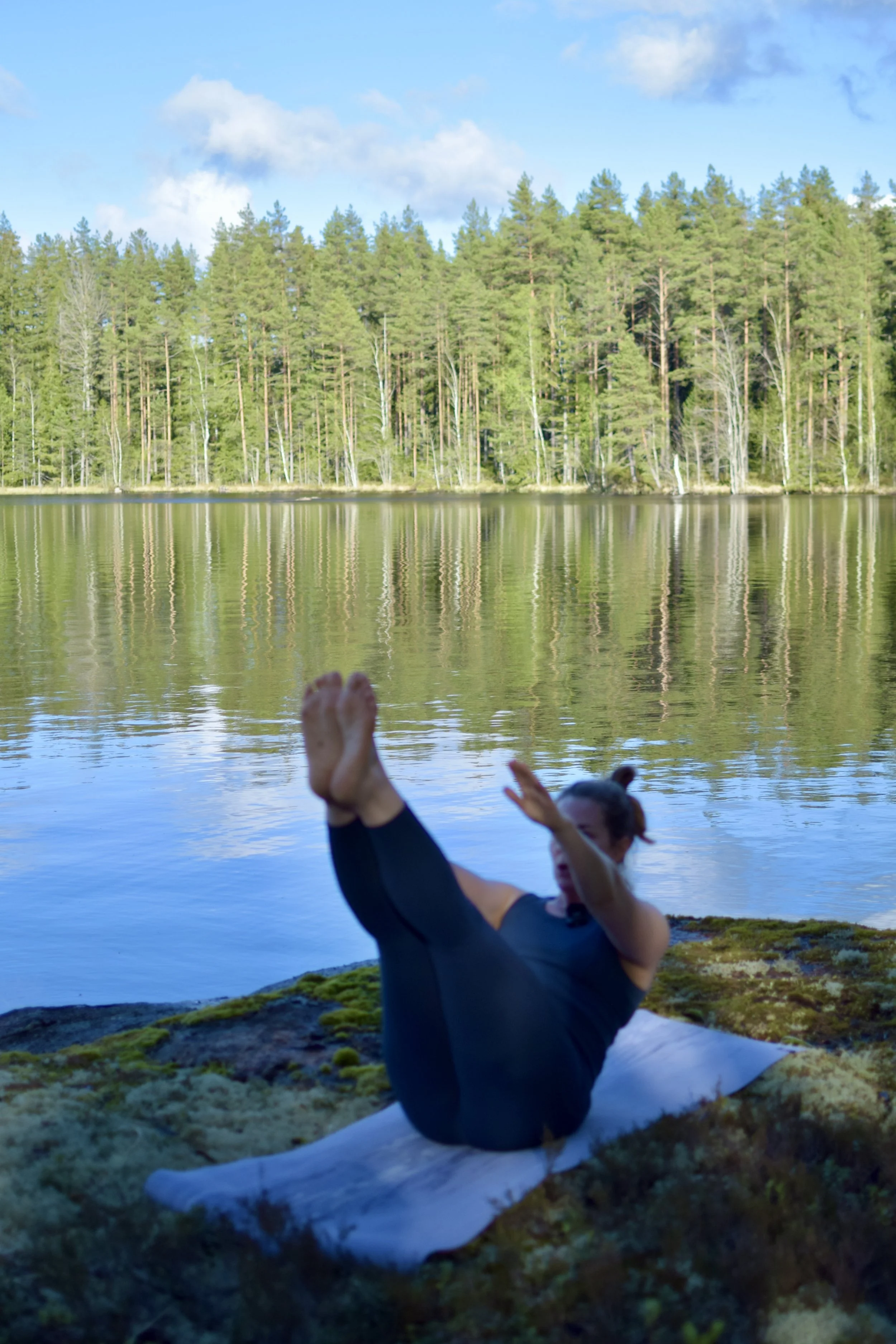 Pilatesliike järvenrannalla kauniissa maisemassa