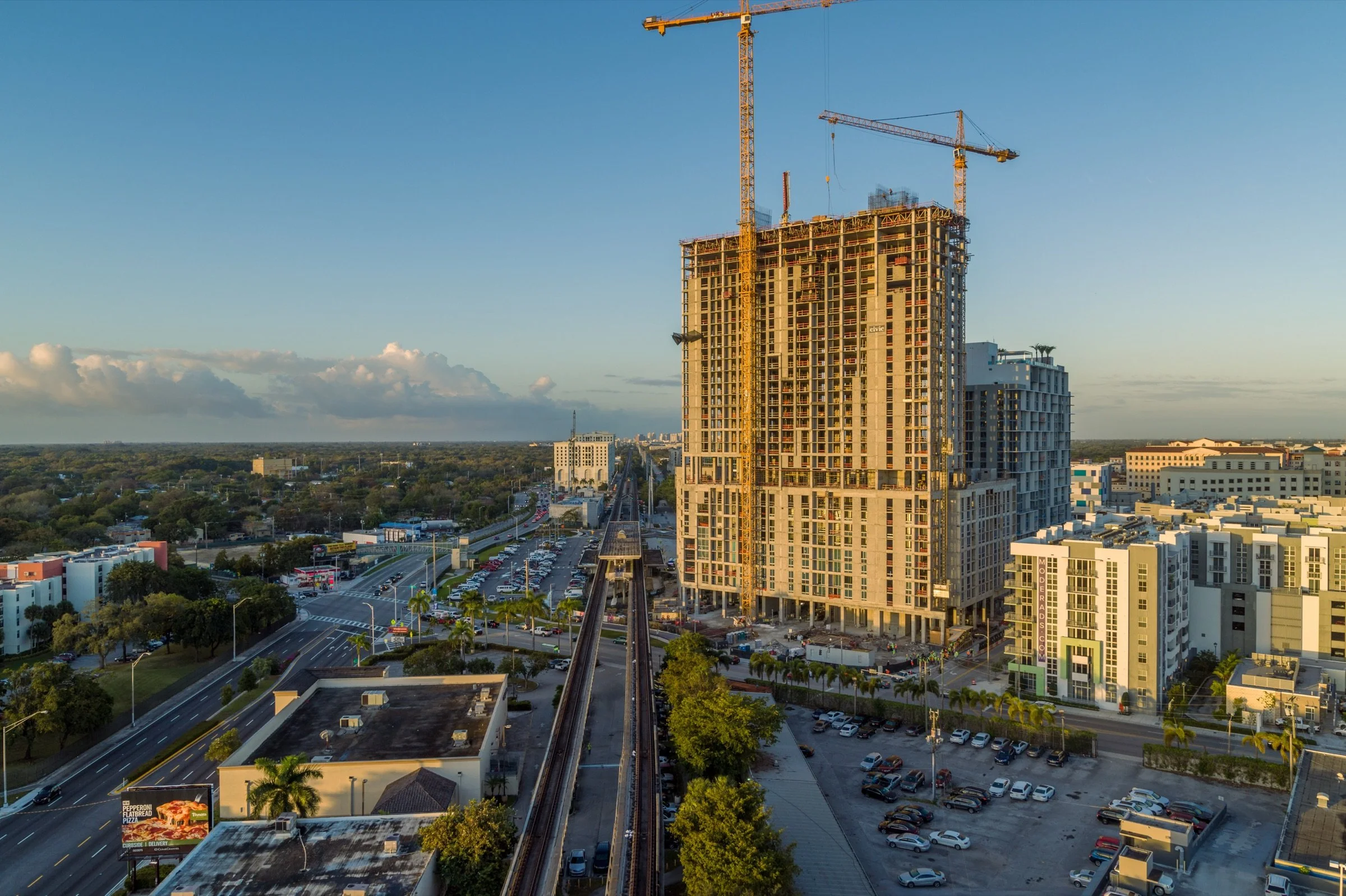 Aerial photograph of a construction site, cranes and surrounding streets