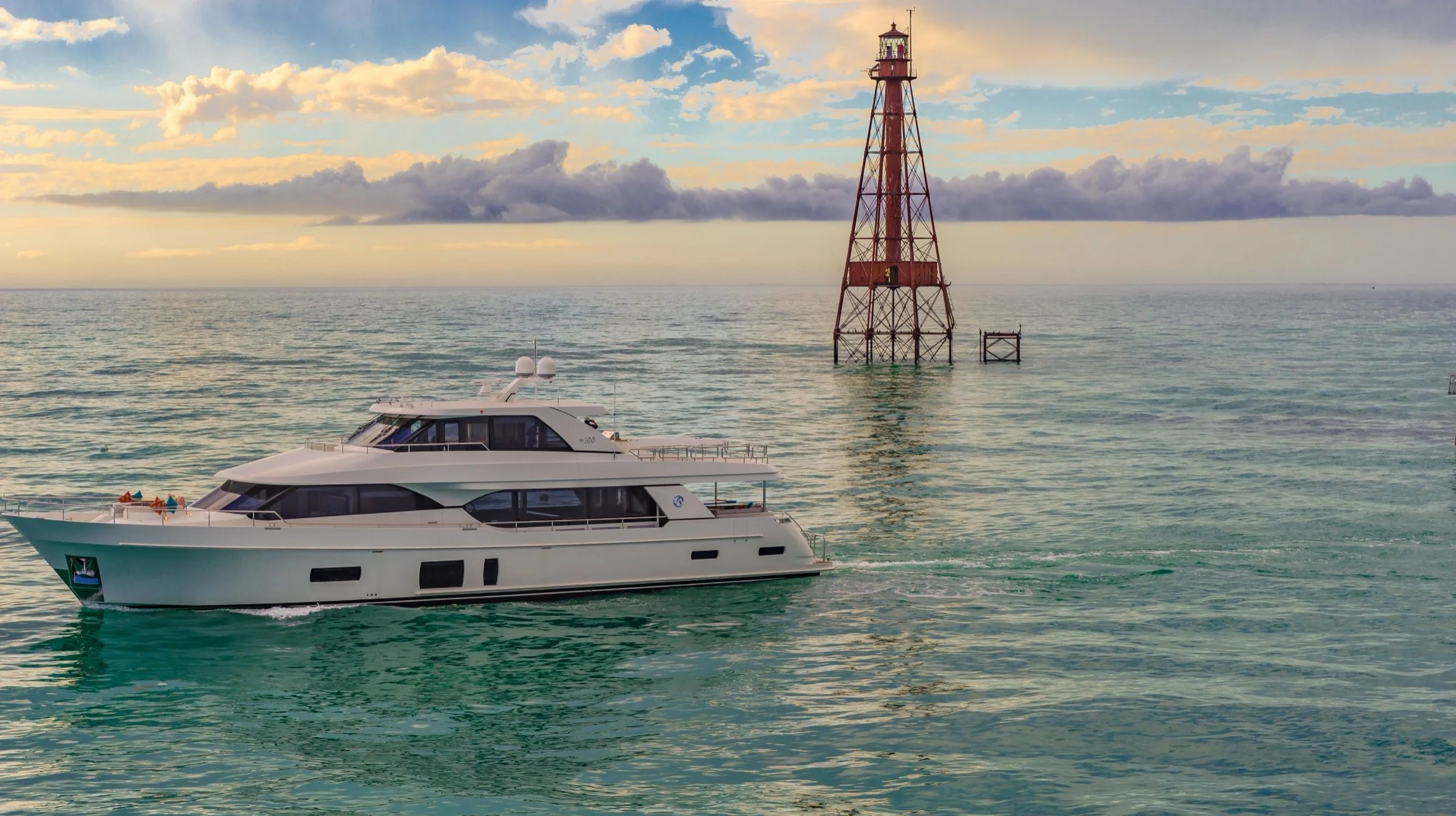 A yacht beside an offshore lighthouse, aerial photograph by Drone Genius