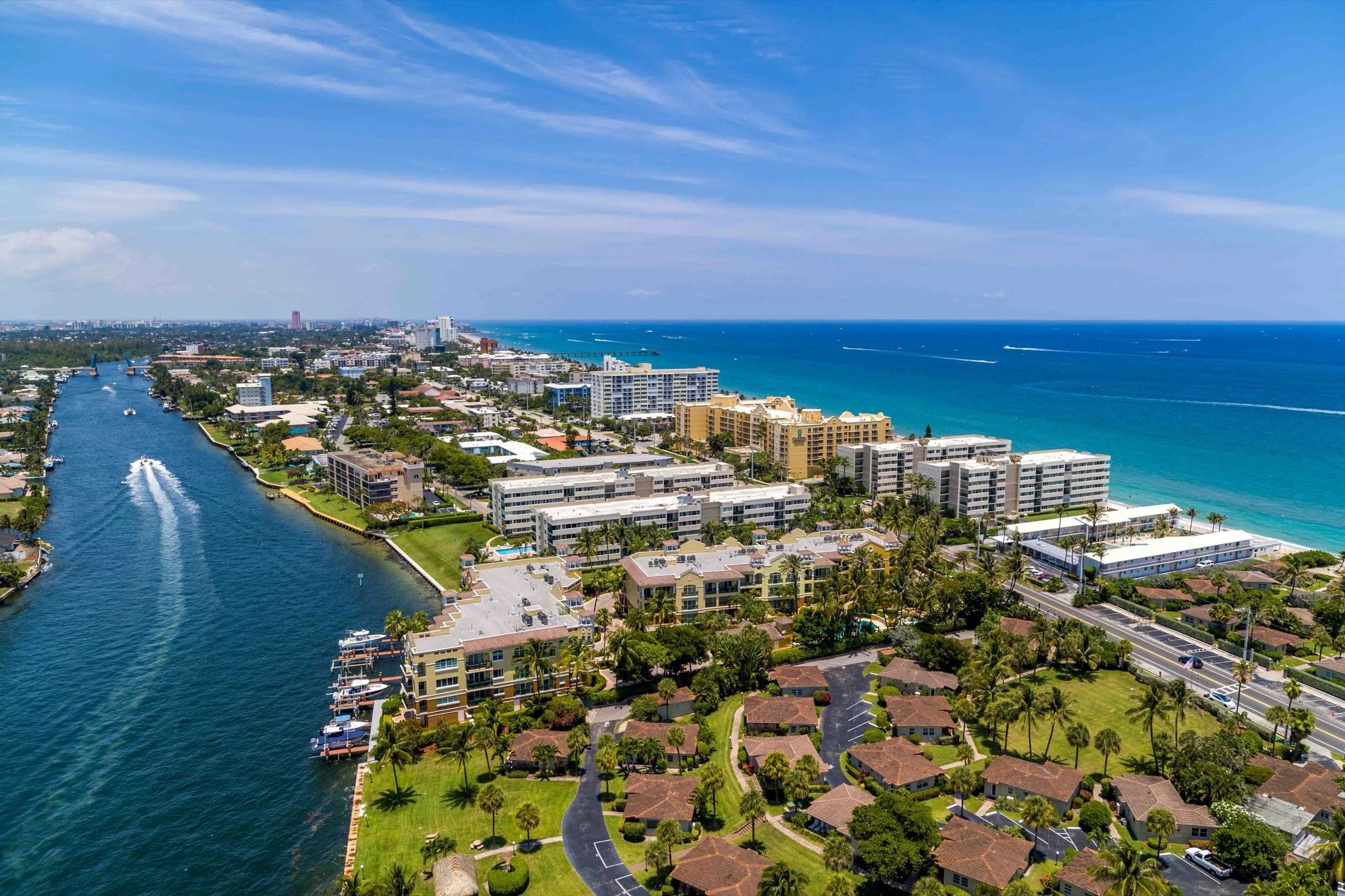 Drone Genius portfolio photograph of waterfront buildings between a waterway and the ocean