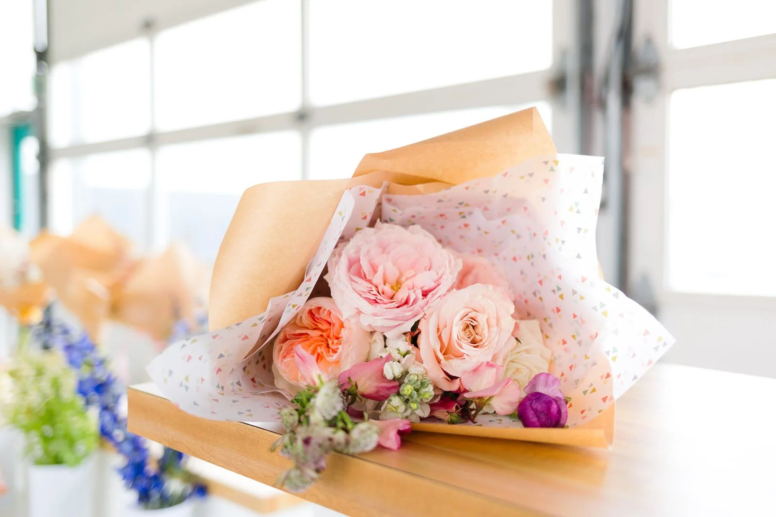 Large wrapped floral bouquet in the foreground of studio space