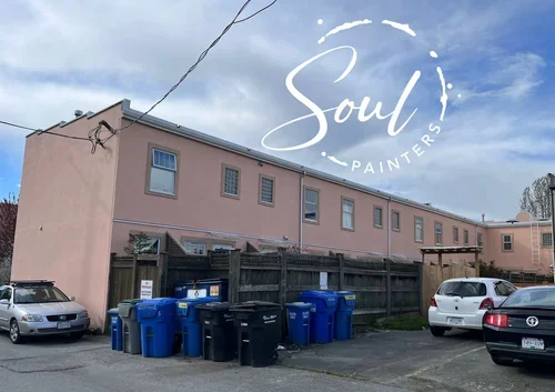 Apartment building with parking lot, blue and black trash bins, partly cloudy sky, and "Soul Painters" logo overlay, painted and maintained by painters offering free exterior painting estimate near you.