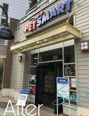 Painters working on the exterior entrance of a PetSmart store with signage and promotional boards, offering free painting estimate and exterior painting services near you.
