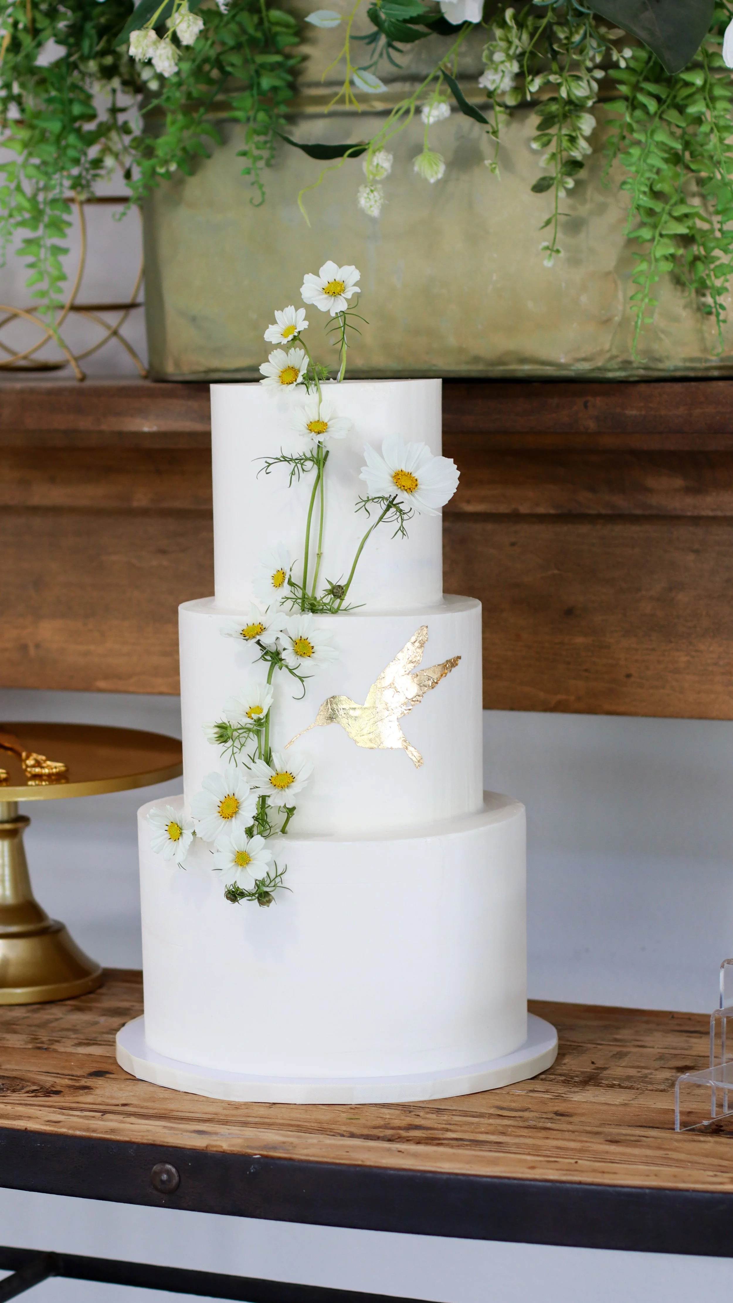 Wedding cake with fresh floral and golf leaf hummingbird by Citrus Blossom Bakery