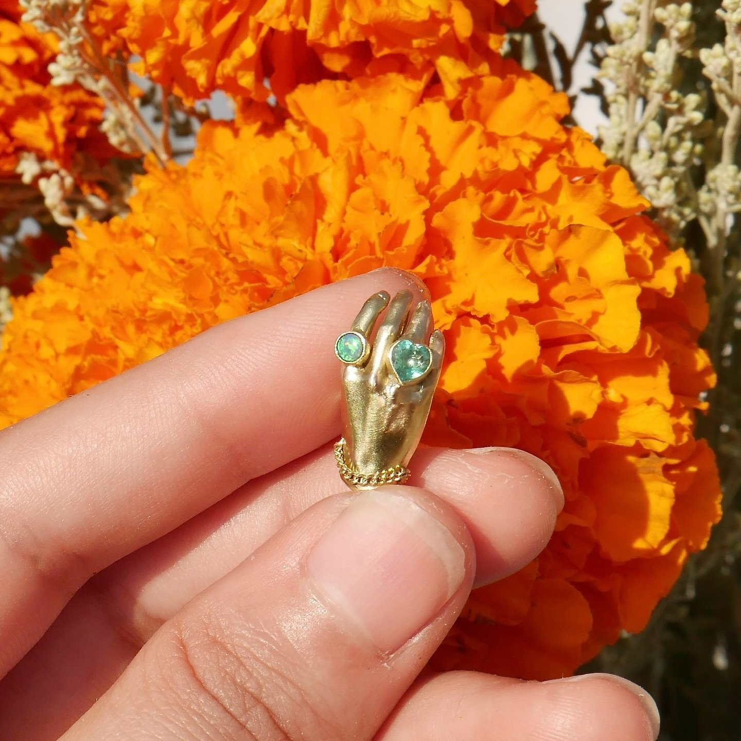 An amulet of love and protection right at your fingertips 🙌🏽✨Golden Hand Milagro with Emerald heart and boulder Opal Available now ✨These flashy green stones set in 18K yellow gold on 14KY gold hand make for an impressive duo 💚💎✨
&bull;
On my web