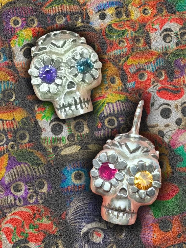 Sharing a couple new sugar skulls, one was a custom request but the teal and purple eyes is available! I mostly do them with a 2mm hole drilled through them so they can go on a chain or on a strand of beads. But some skulls can be made with a bail lo