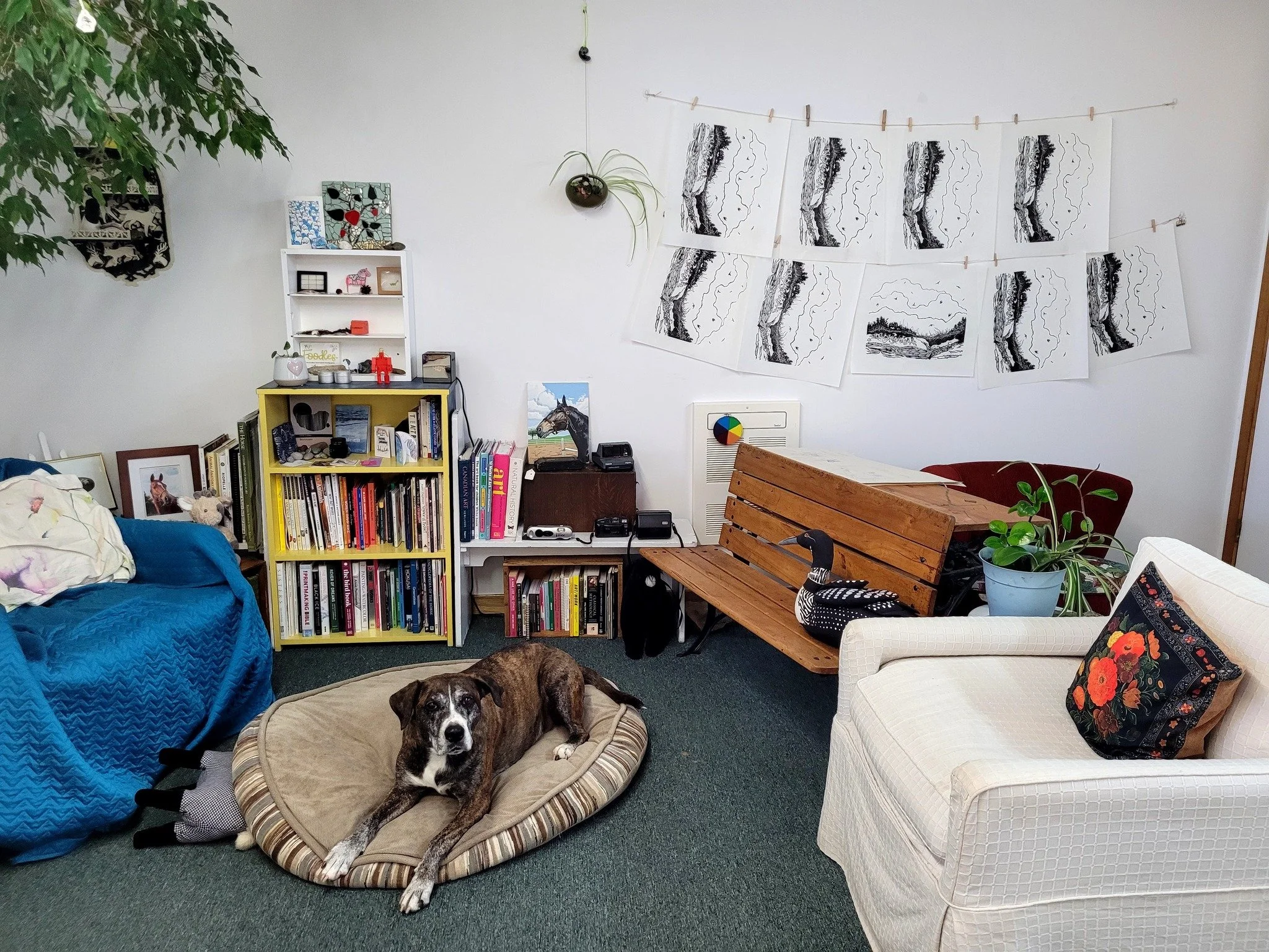Sadie Rose relaxes in the cozy corner while fresh woodcut prints hang to dry on the wall. 