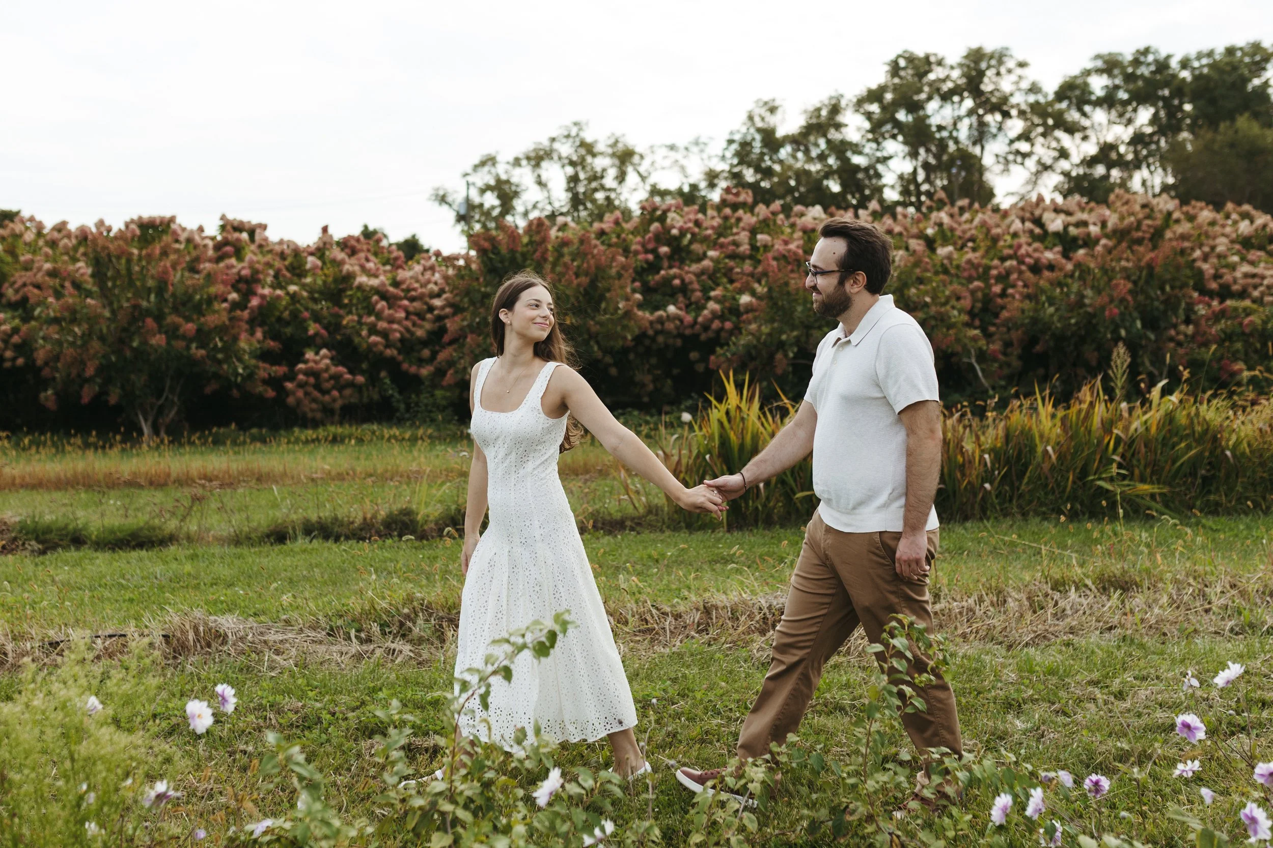 Couple Holding Hands at their Engagement Session at Salt Air Farm