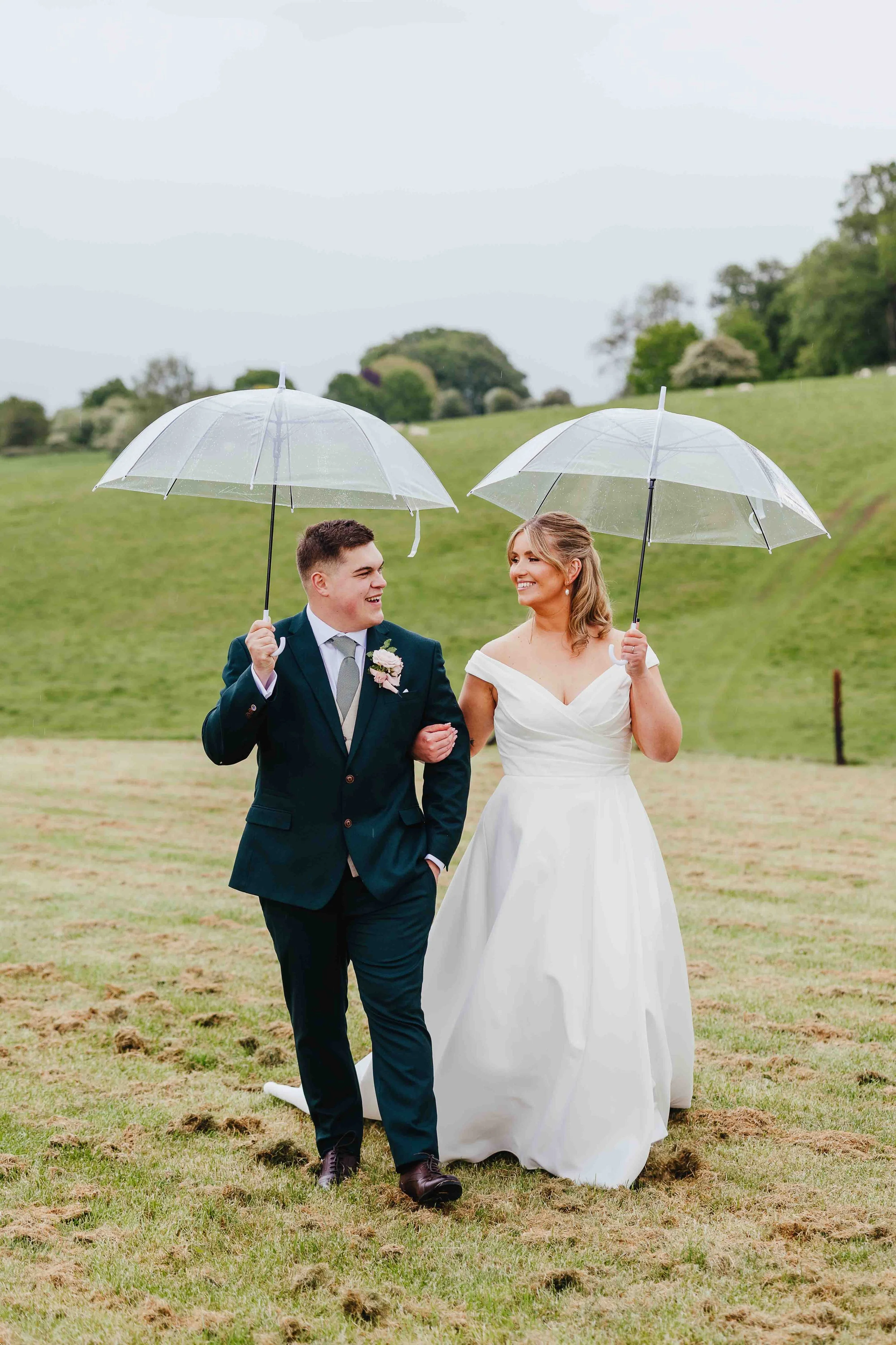 Couple walking under umbrellas at Deer Park Barn