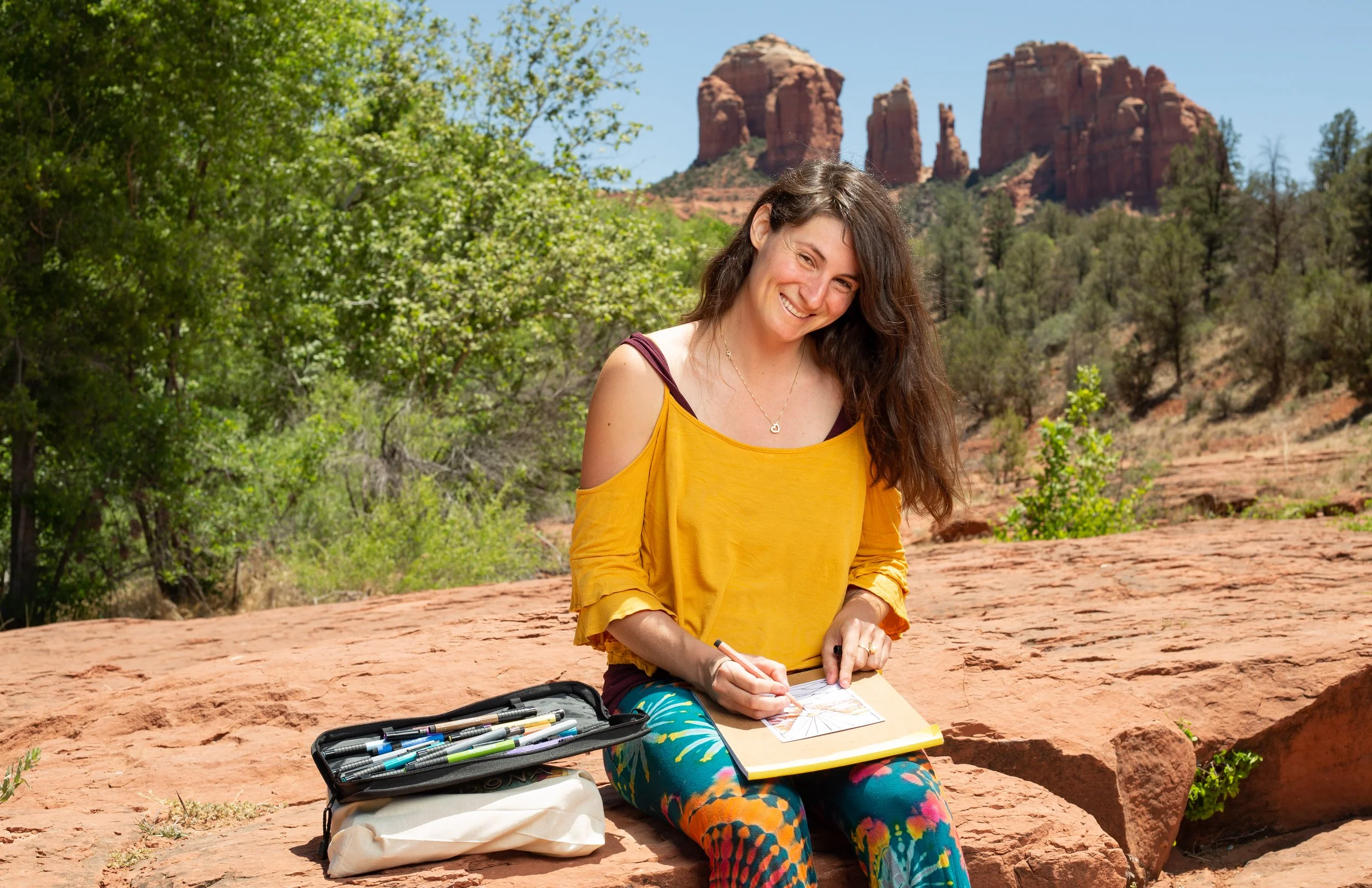 Portrait of artist Savage Bliss posing with supply in canyon desert