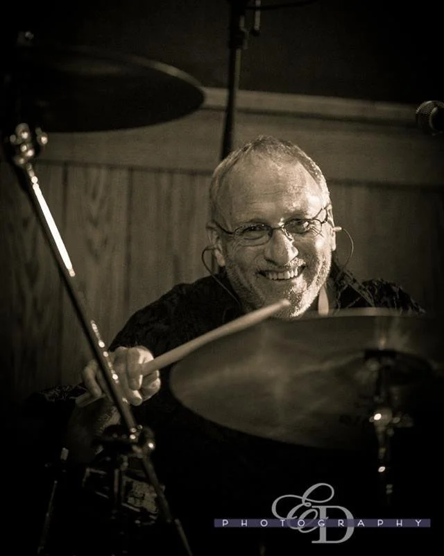 Lightly colored image of William Babin playing drums or precussions