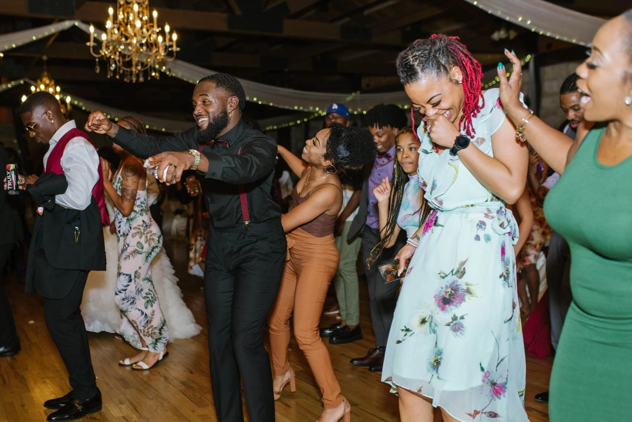 Groom dances with his family on packed dance floor.