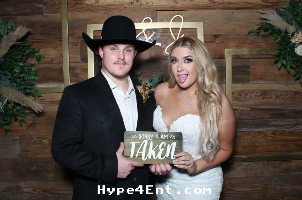 The bride and groom are taking a picture together at the photo booth