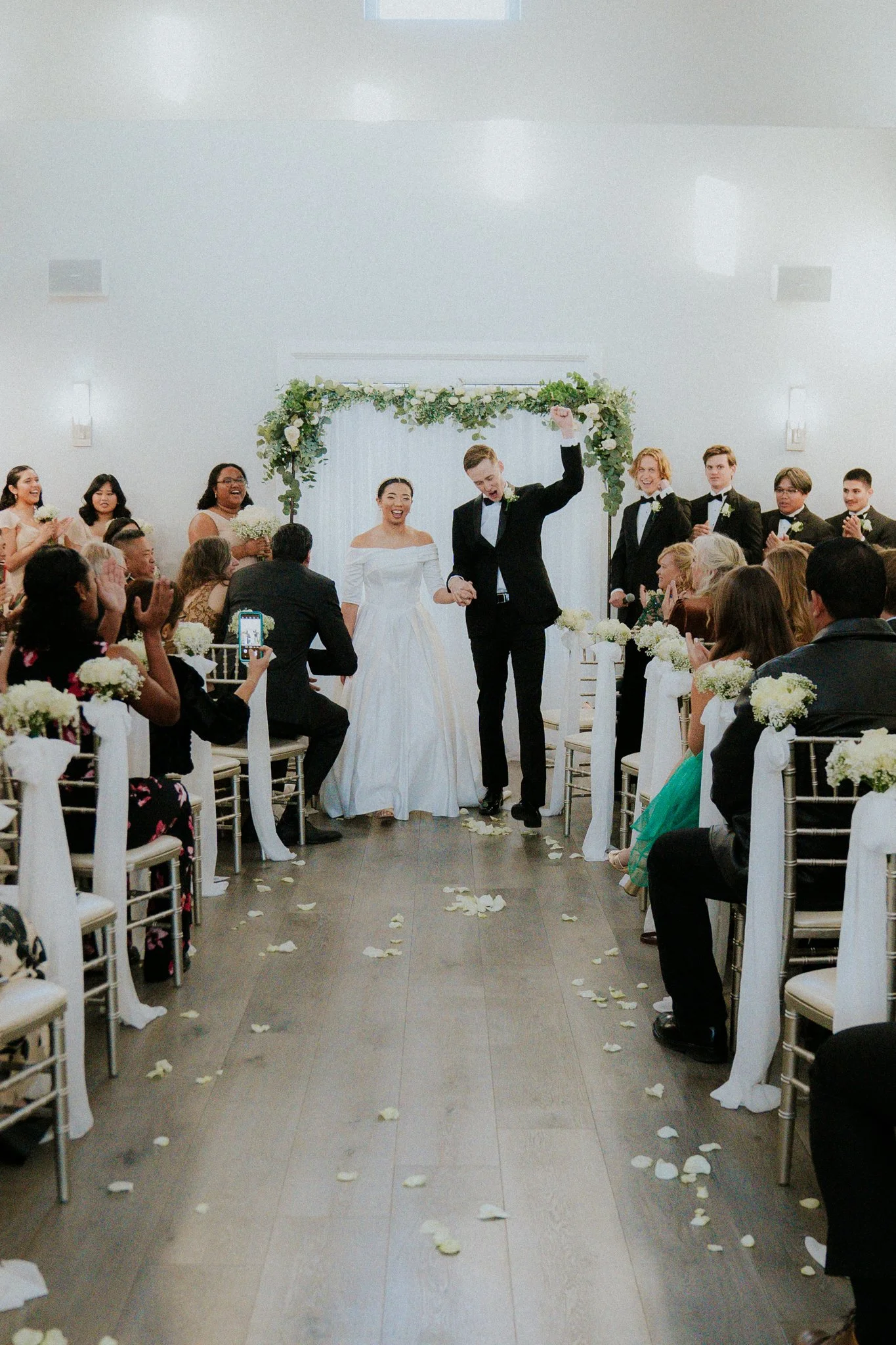 A couple gets married in a wedding ceremony with guests watching and celebrating.