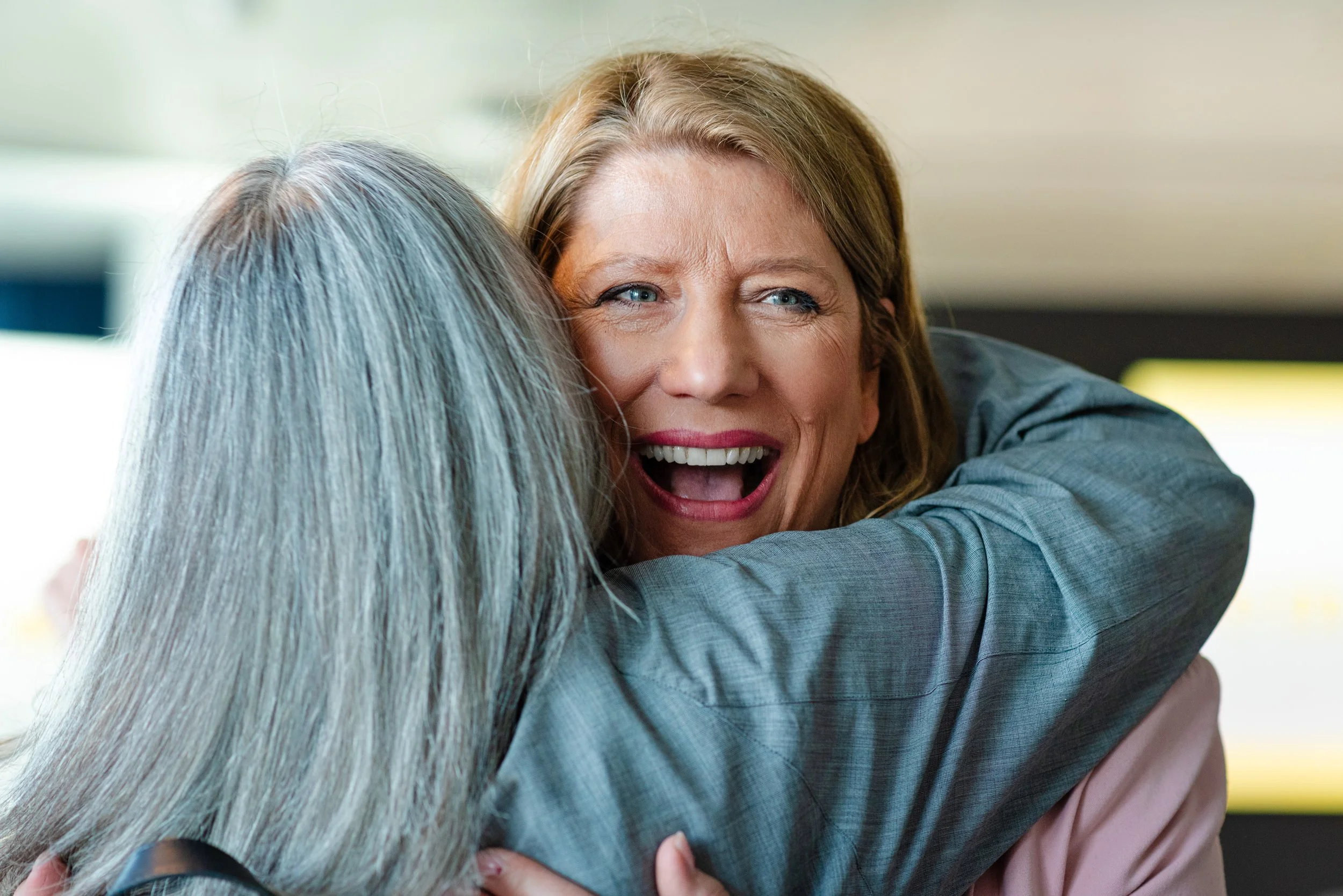 Two middle-aged women hugging each other at a networking event. EmPower Event.

Women engaging in a discussion on stage during a conference, with an audience present, a screen displaying the word 'emPOWER' in the background.

Portrait photography - p