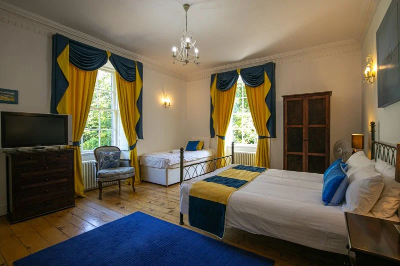 SOLYMAR

A bright triple bedroom, with a yellow and blue theme.

The large ensuite bathroom has a bath and shower.