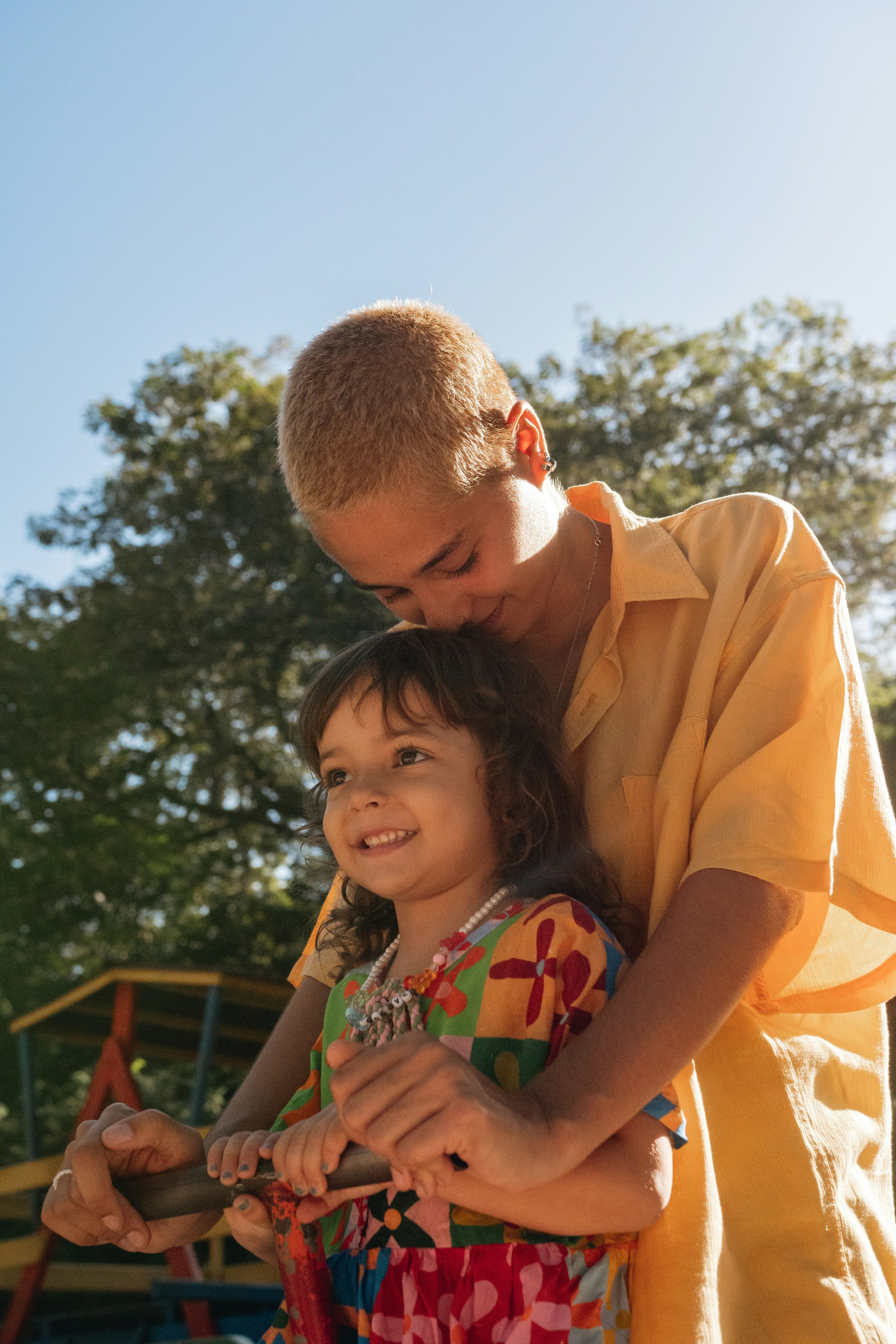 A joyful child is held closely by a caring adult, illustrating the power of healthy emotional regulation and what’s possible when cycles of emotionally immature parenting are broken.