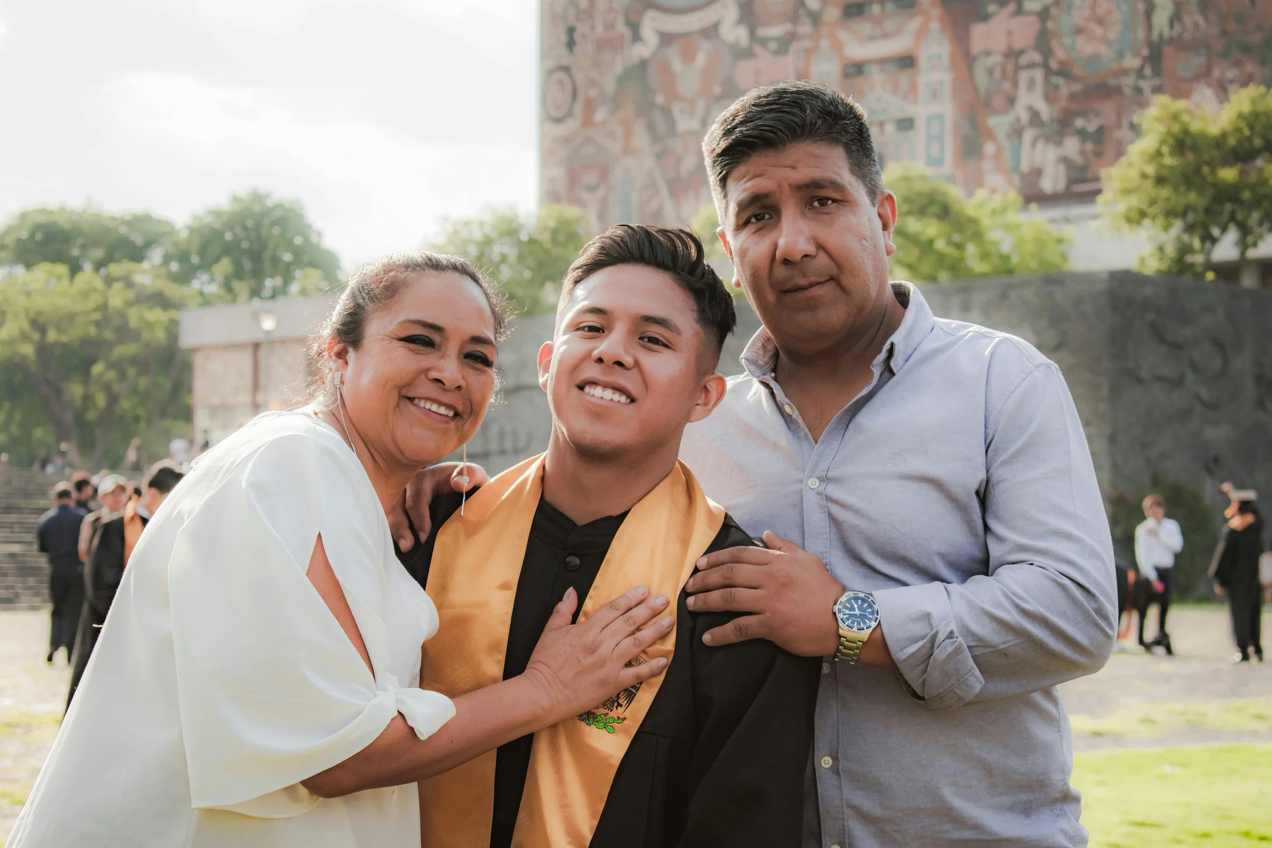 Graduate celebrating with parents at an outdoor ceremony, highlighting teen college prep milestones and the role of teen therapy Coral Springs families rely on.