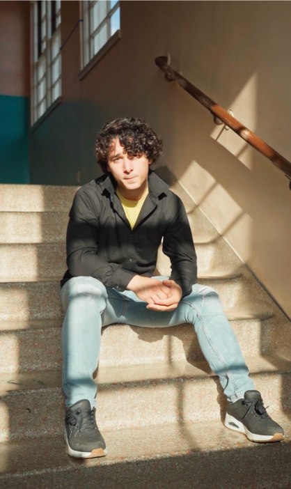 Teen sitting on school steps in sunlight, reflecting stress before college and how teen therapy in Coral Springs can support life skills for young adults.