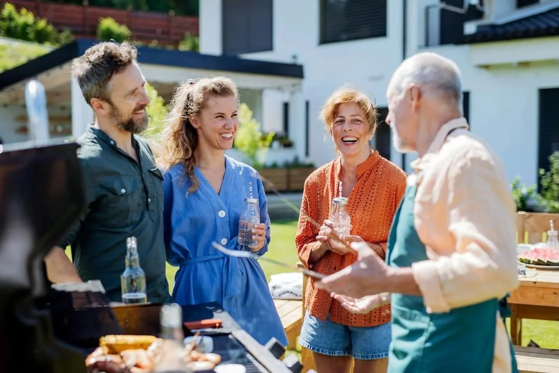 family smiling together around a bbq
