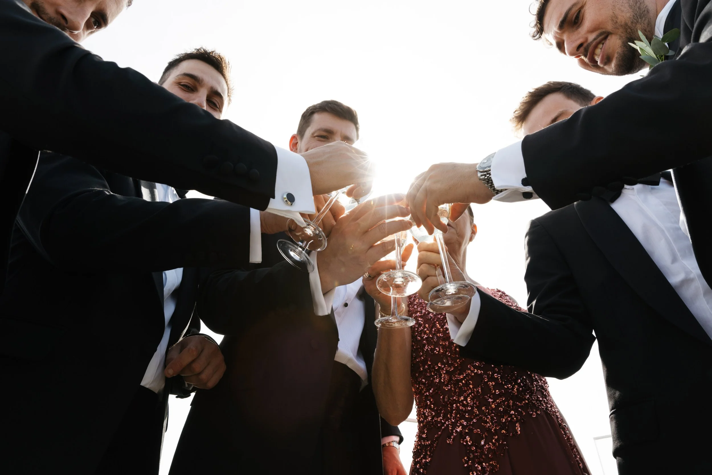 Group of people in formal attire clinking champagne glasses in celebration.