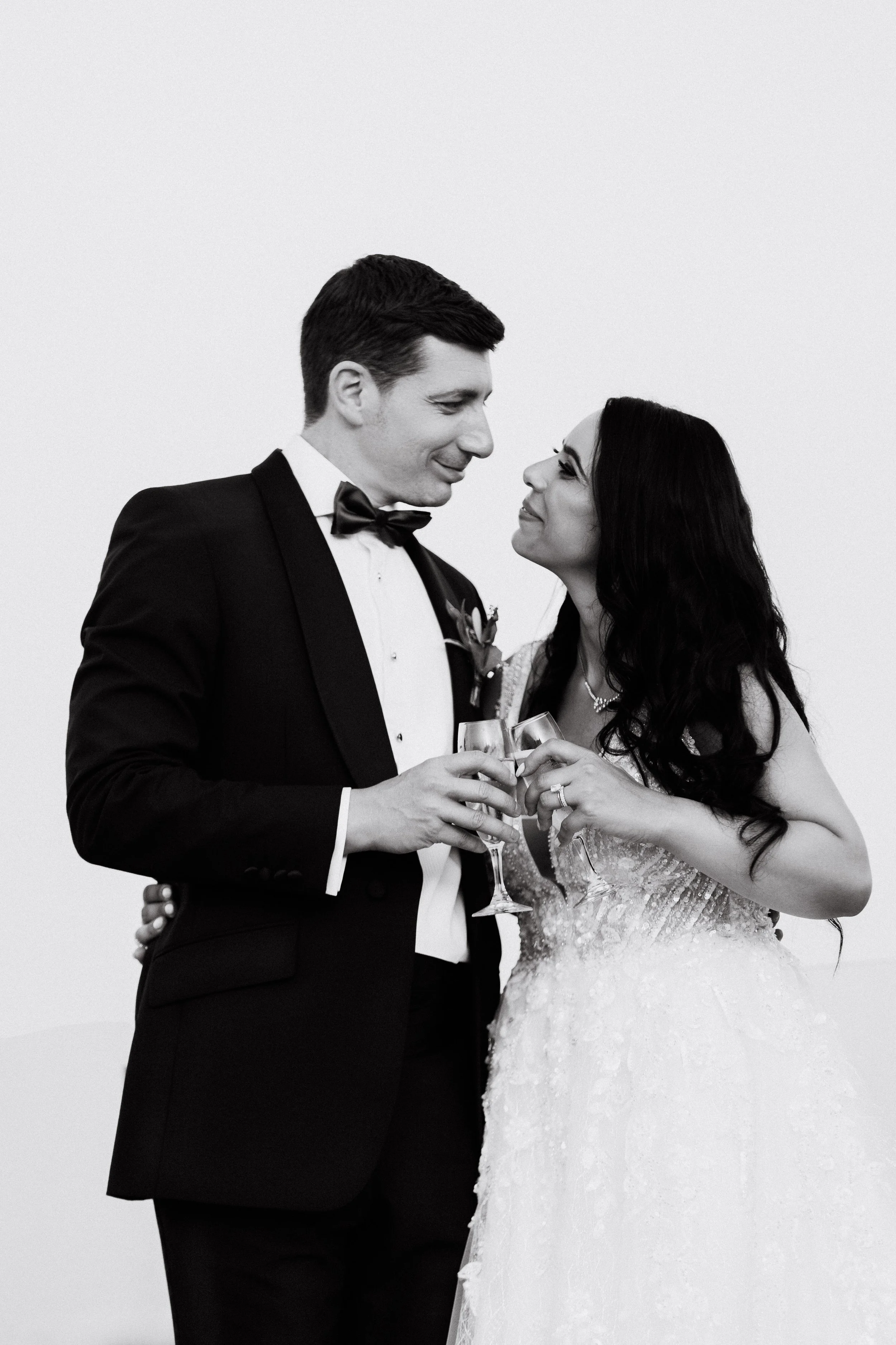 Bride and groom toasting with champagne glasses, black and white