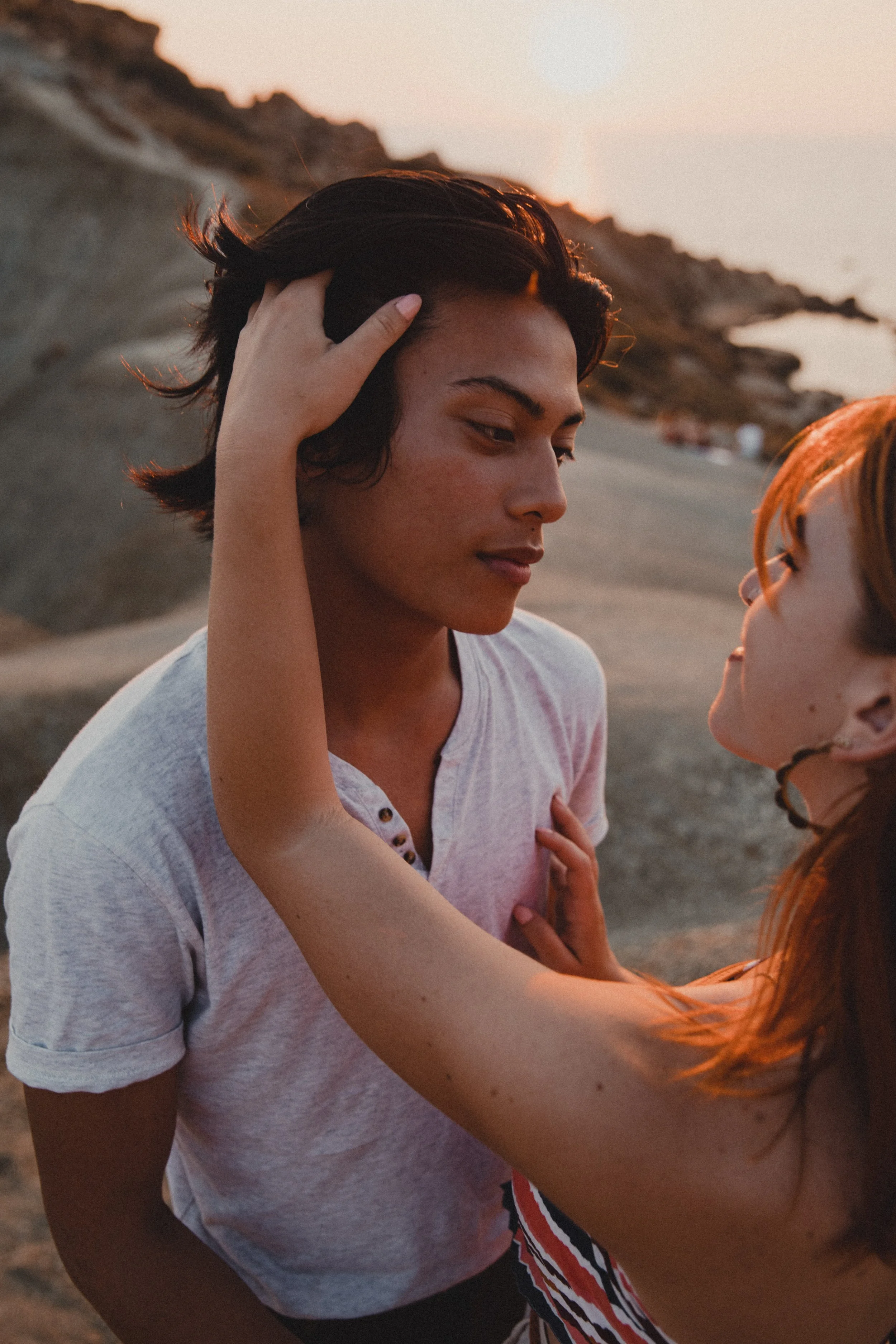 Couple embracing at sunset on a rocky beach
