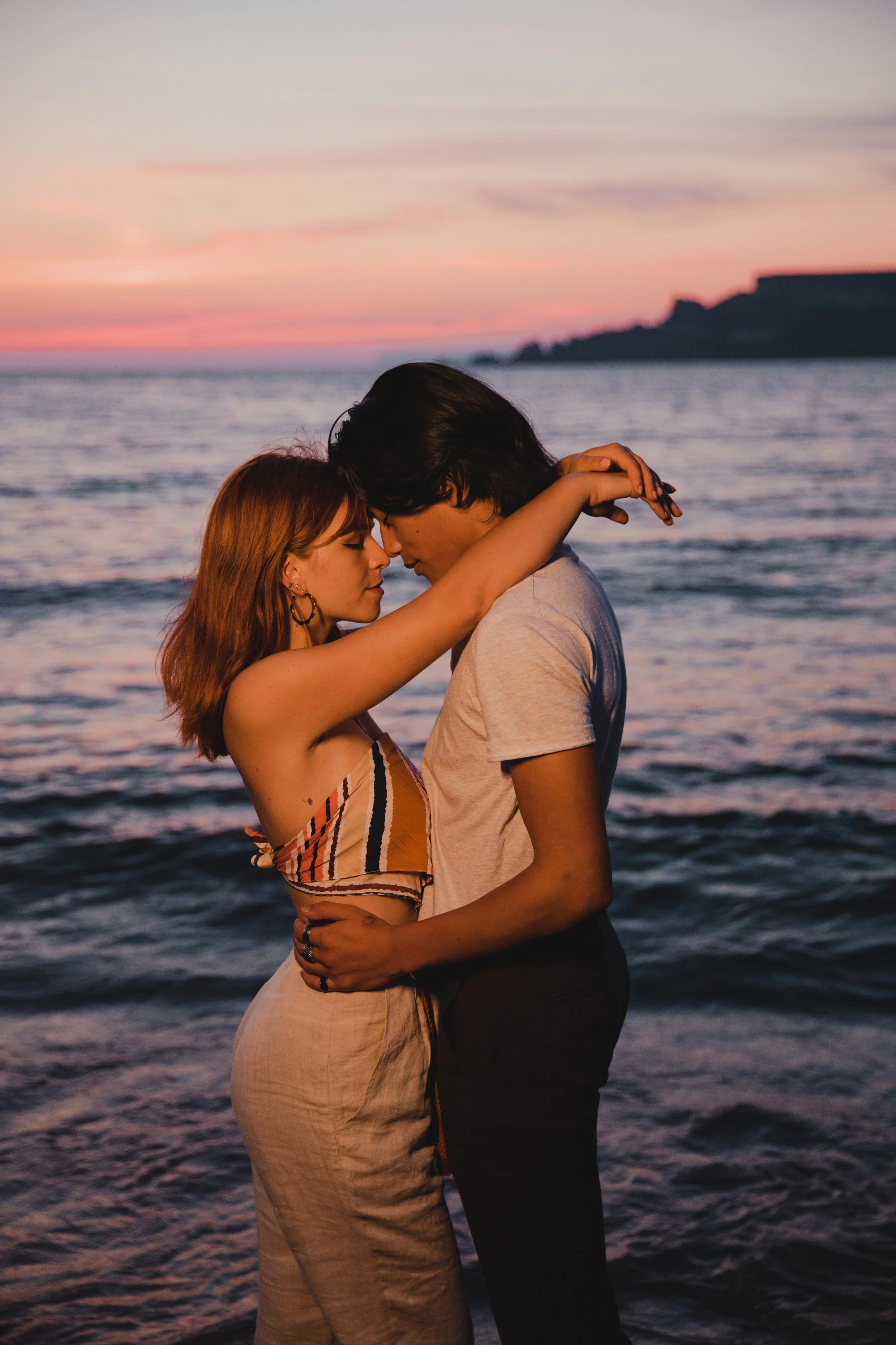 Couple embracing on beach at sunset