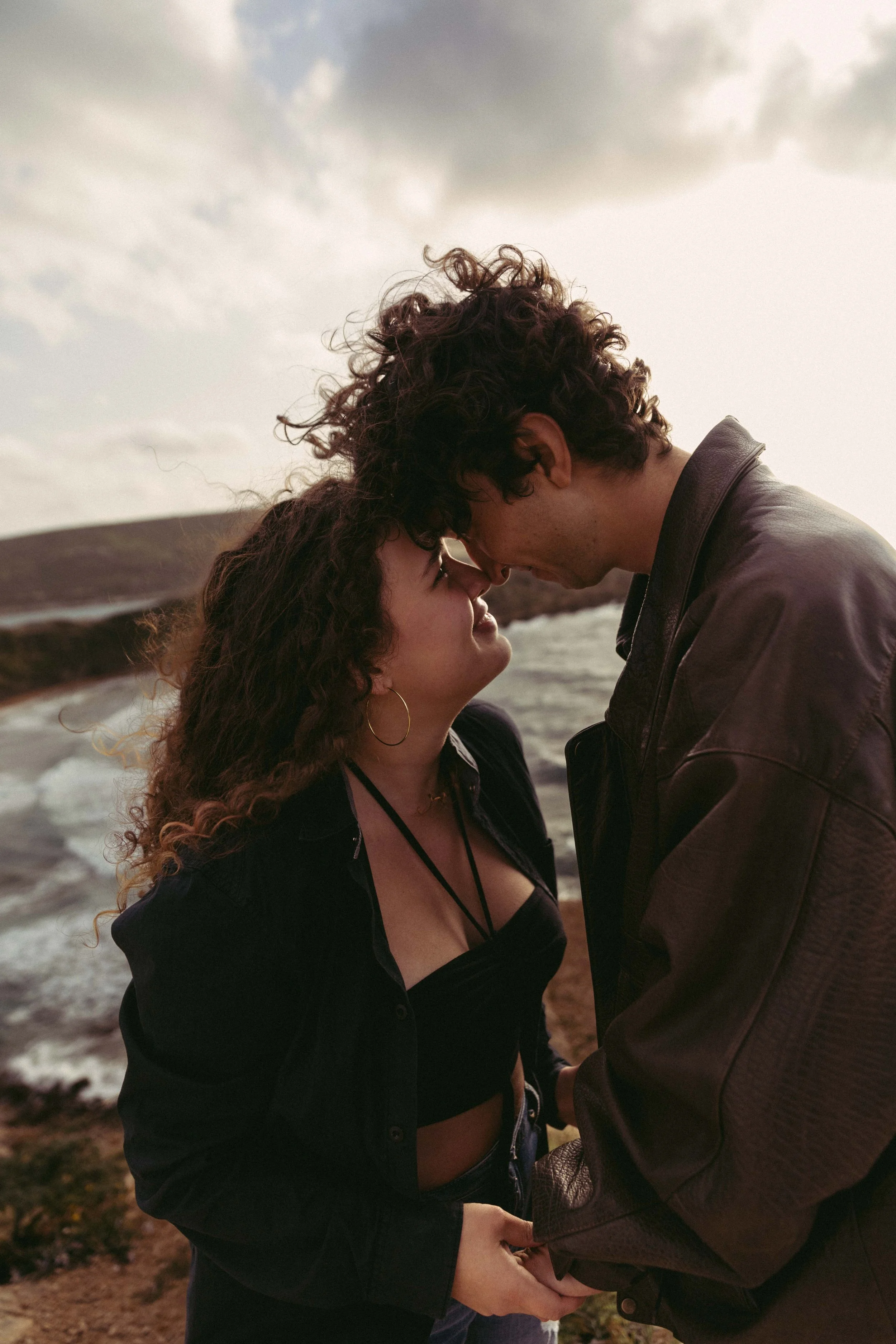 Couple embracing near a coastal landscape