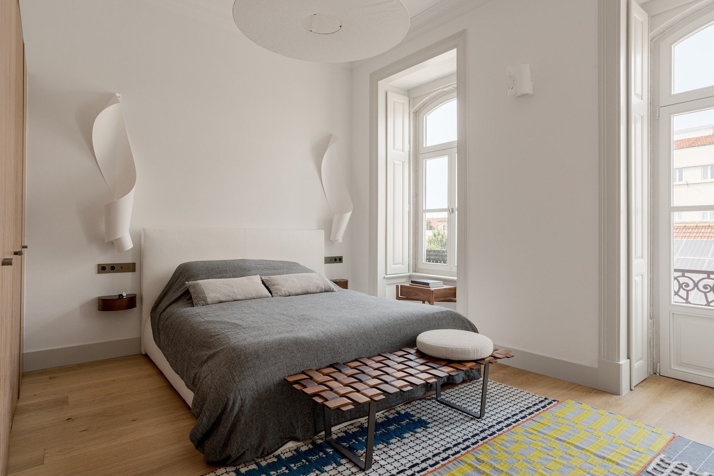A serene retreat in the heart of Lisbon. ✨ ⁠
In this bedroom from our Voz do Oper&aacute;rio project, every element is chosen to honor the building&rsquo;s history while embracing modern comfort. The soft curves of the wall light contrast with the ro