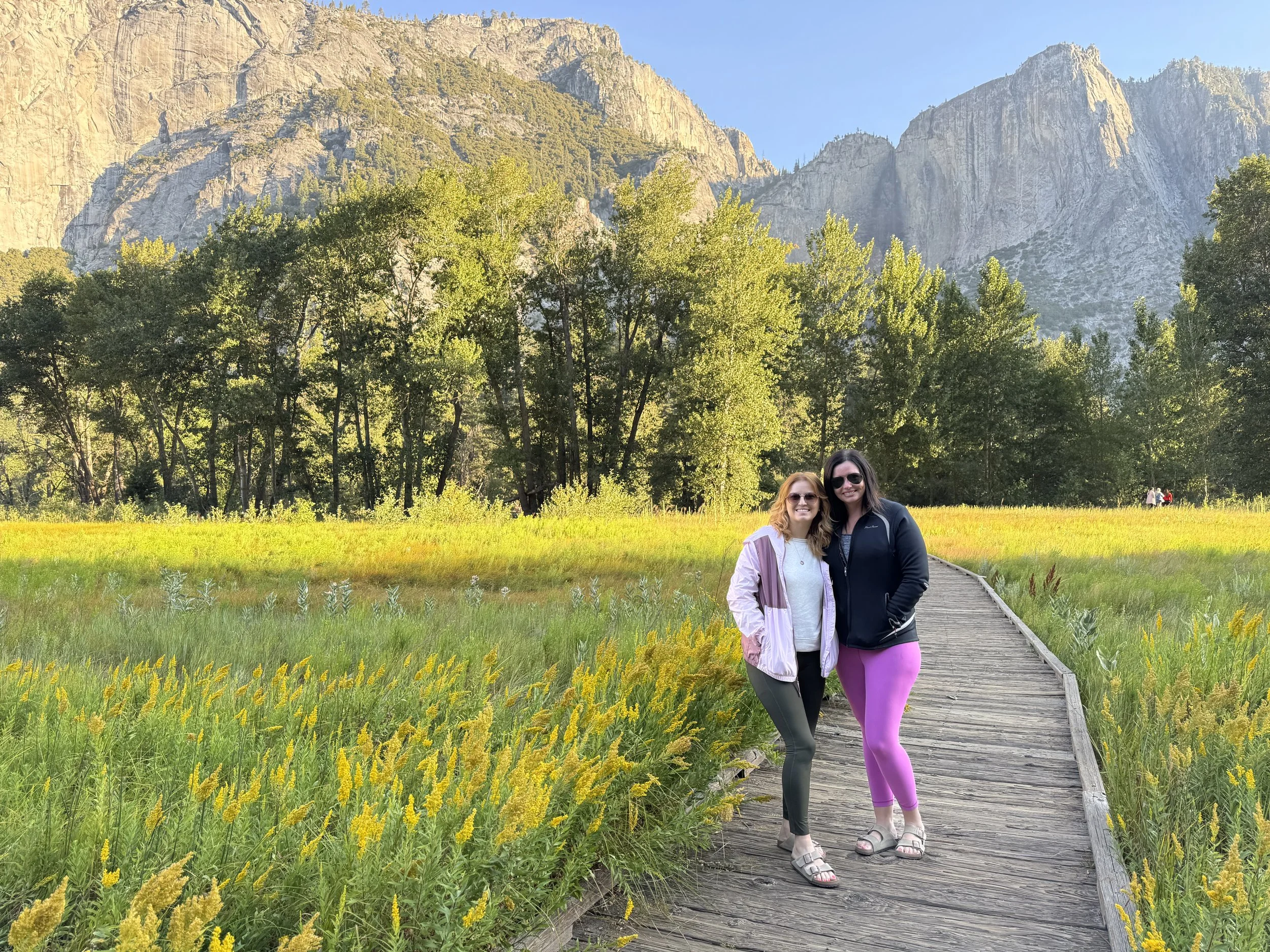 Girls in Yosemite Valley with yellow wildflower blooms at Cook’s Meadow