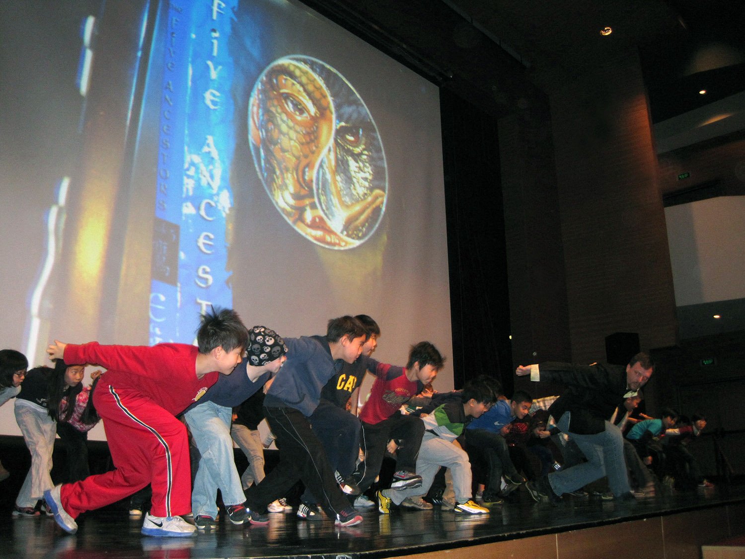 Author Jeff Stone in Shanghai China teaching kids Eagle Style kung fu on large stage.