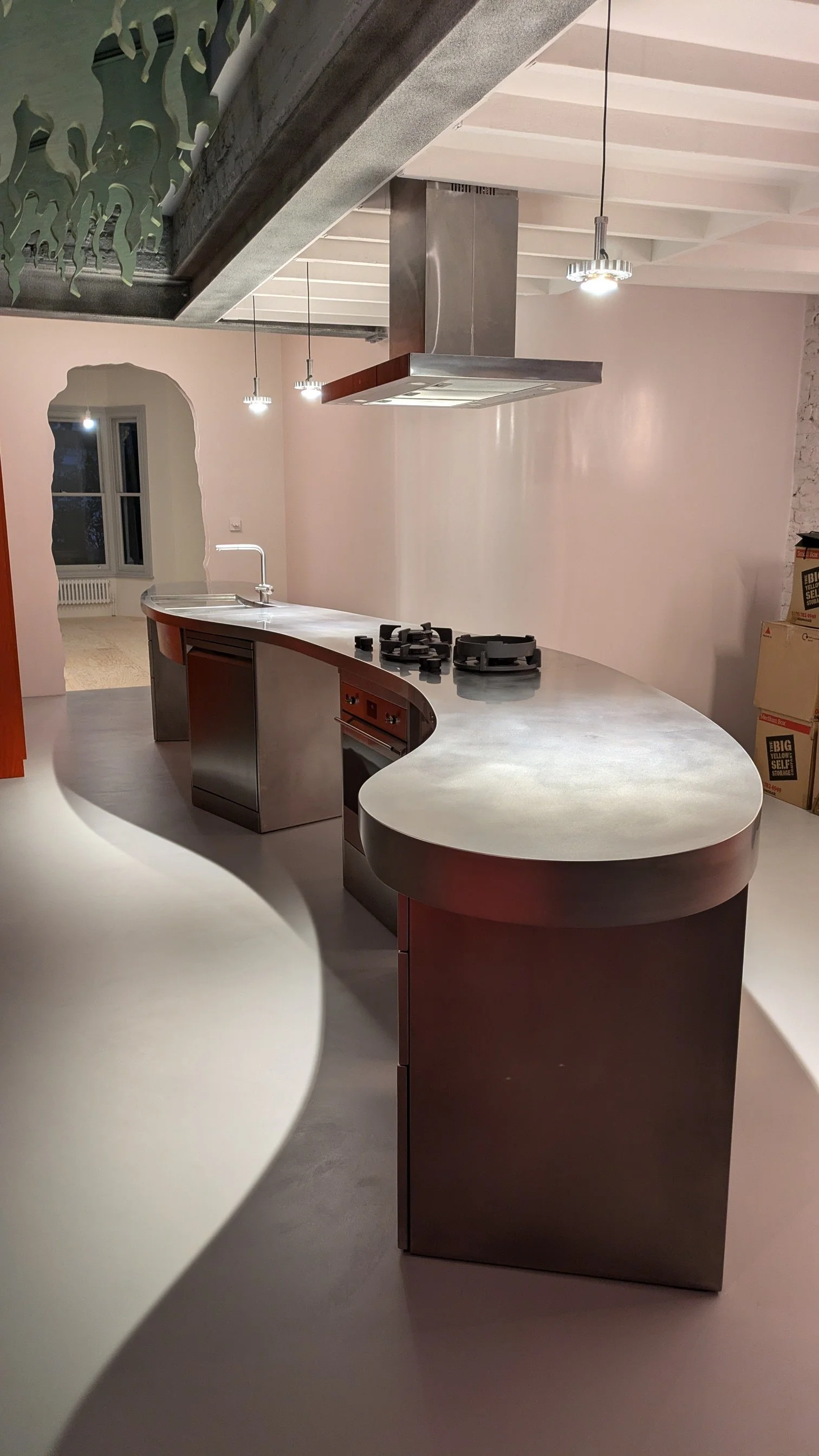 A Long wavy kitchen island made completely in stainless steel