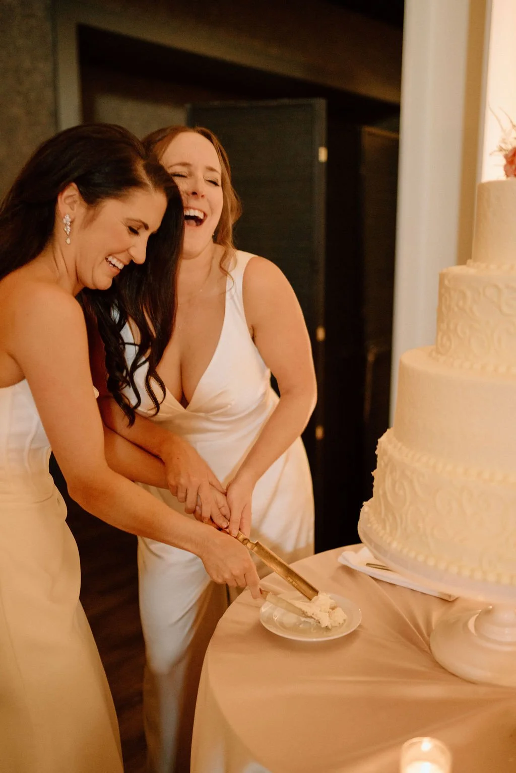 brides cutting cake during their ivy at the ellis preserve wedding reception